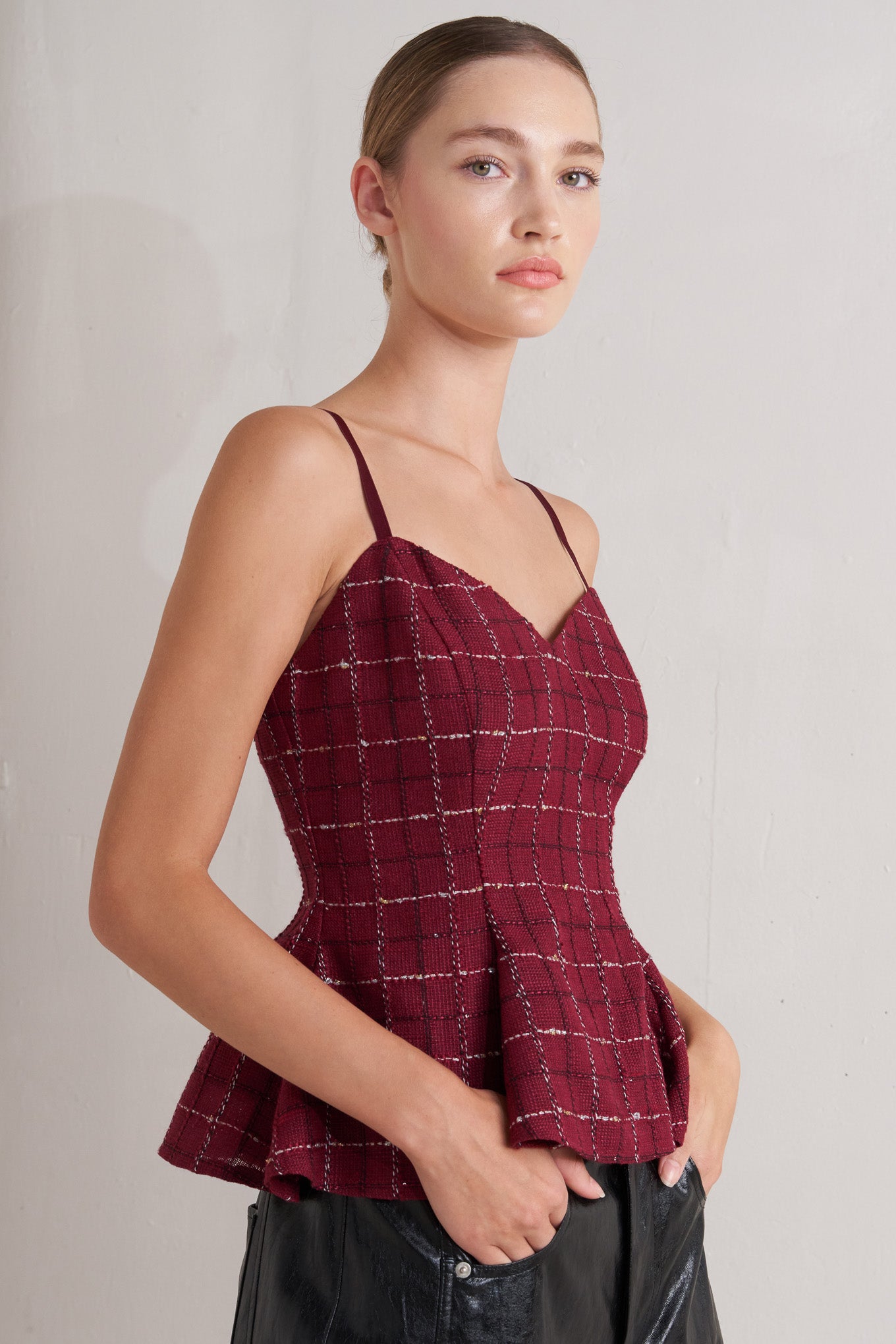 A tweed cami top featuring straps, peplum and back zipper closure