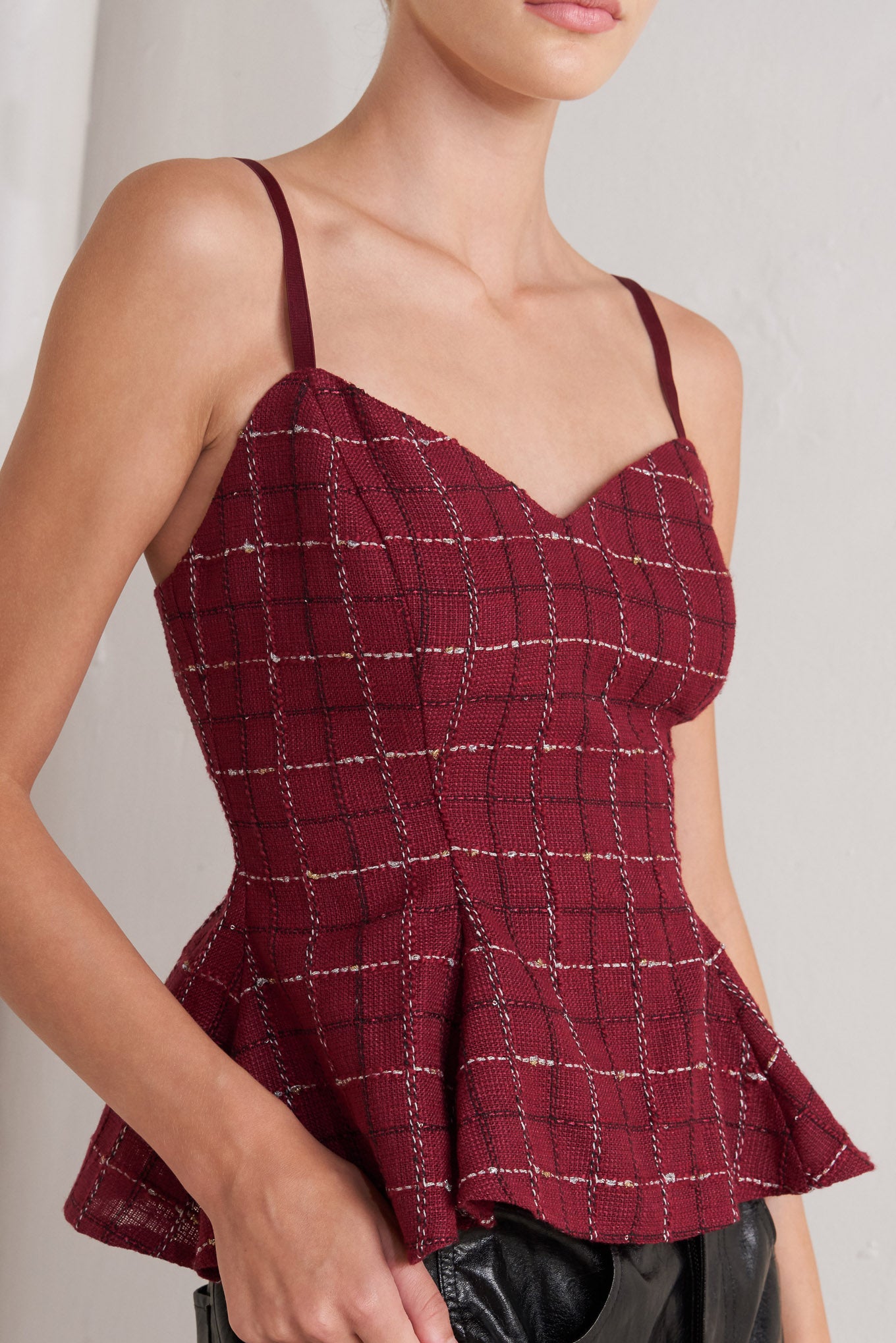 A tweed cami top featuring straps, peplum and back zipper closure