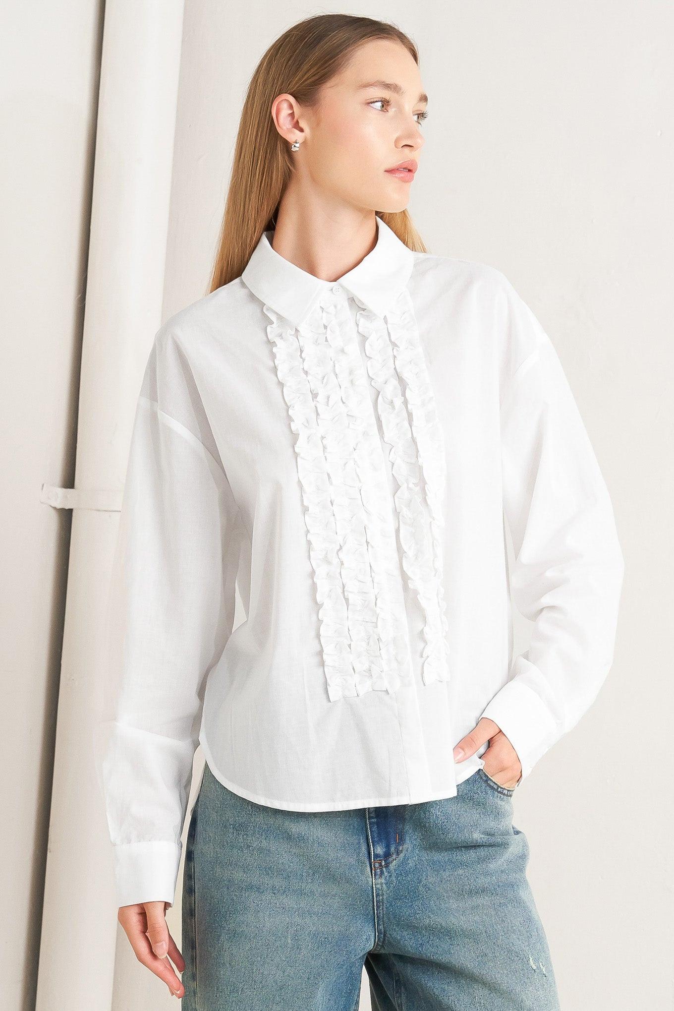 A solid woven top with a collar, button-down front, long sleeves, and front ruffle detail.