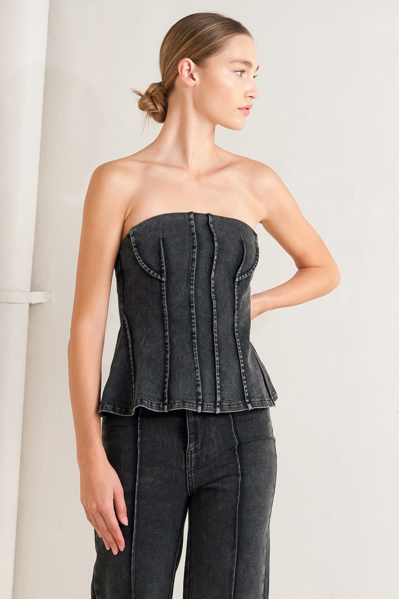 A washed denim top featuring strapless neckline and back zipper closure