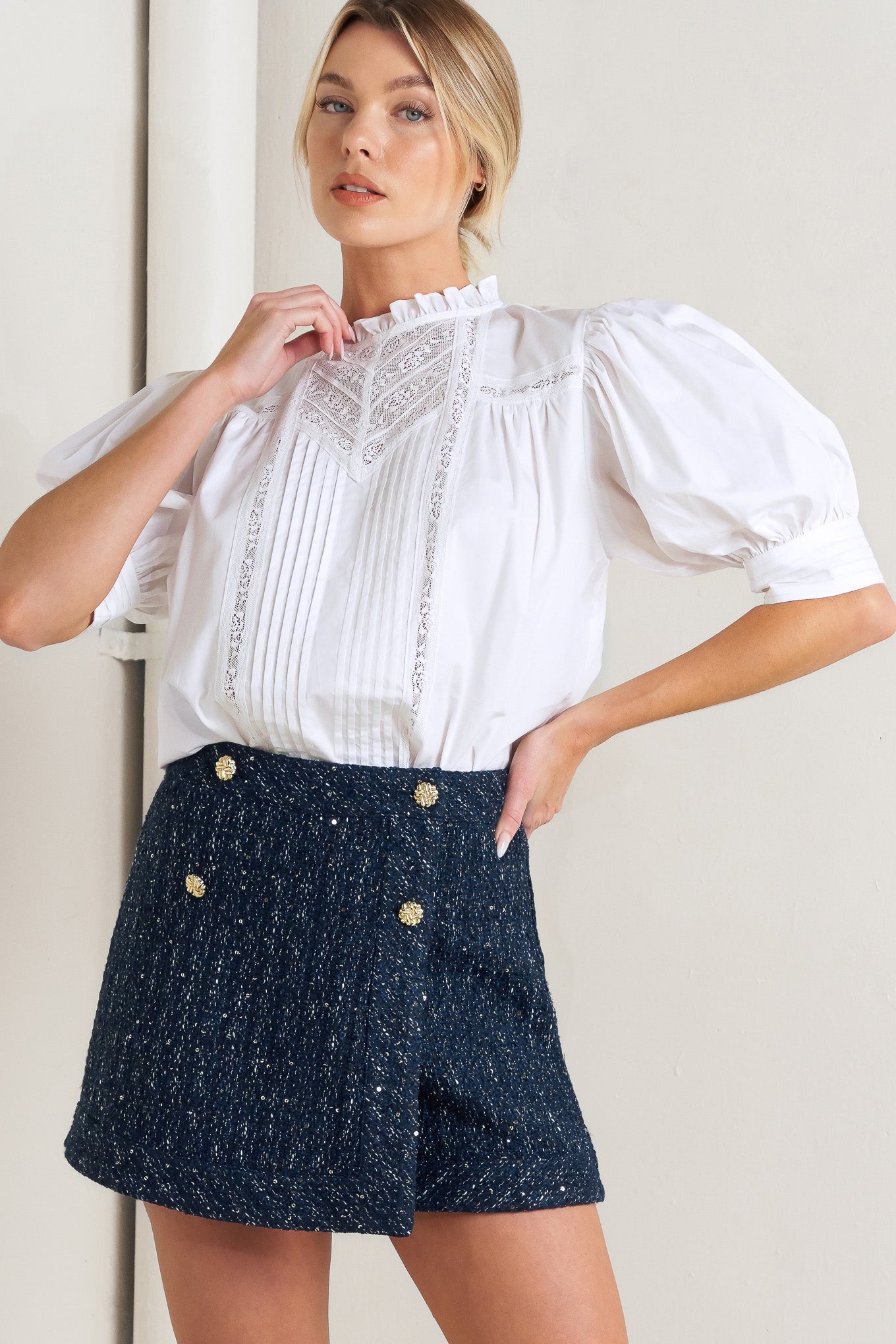 A solid woven top featuring ruffled high neck, pintuck and lace inset, short puff sleeve and back neck button closure
Details:
Self: 100% Cotton Exclusive of Decoration
Size & Fit
- Model is 5`8" And Wearing Size Small
- Measurements Taken From Size Small
- Approx. Length: 23"