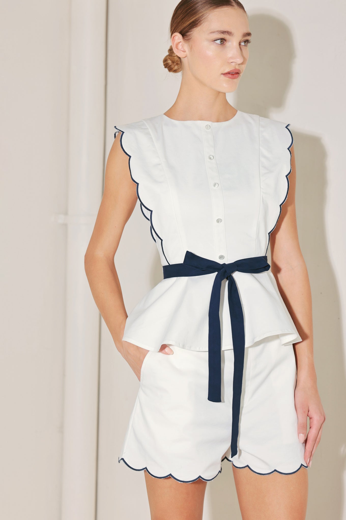 A solid woven top featuring round neckline, button down detail, scallop edge, contrasting tie and back zipper closure. Matching short FP1901-T
Details:
Self : 97% Cotton 3% Spandex
Contrast : 97% Cotton 3% Spandex
Size & Fit
- Model is 5`8" And Wearing Size Small
- Measurements Taken From Size Small
- Approx. Length: 23"