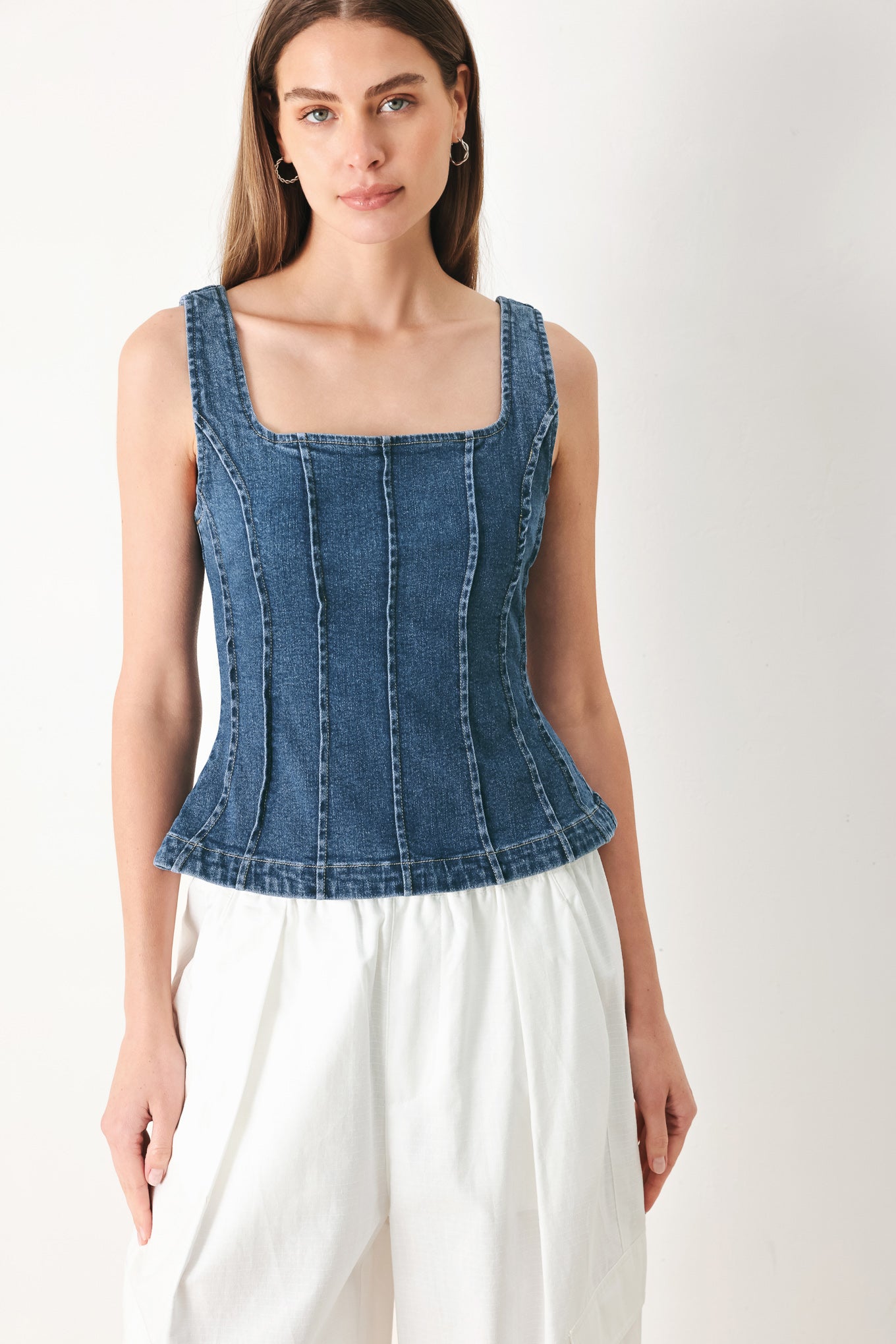 Woman wearing a sleeveless denim corset top with square neckline, peplum and back zipper closure | FREEMARKET | Flying Tomato