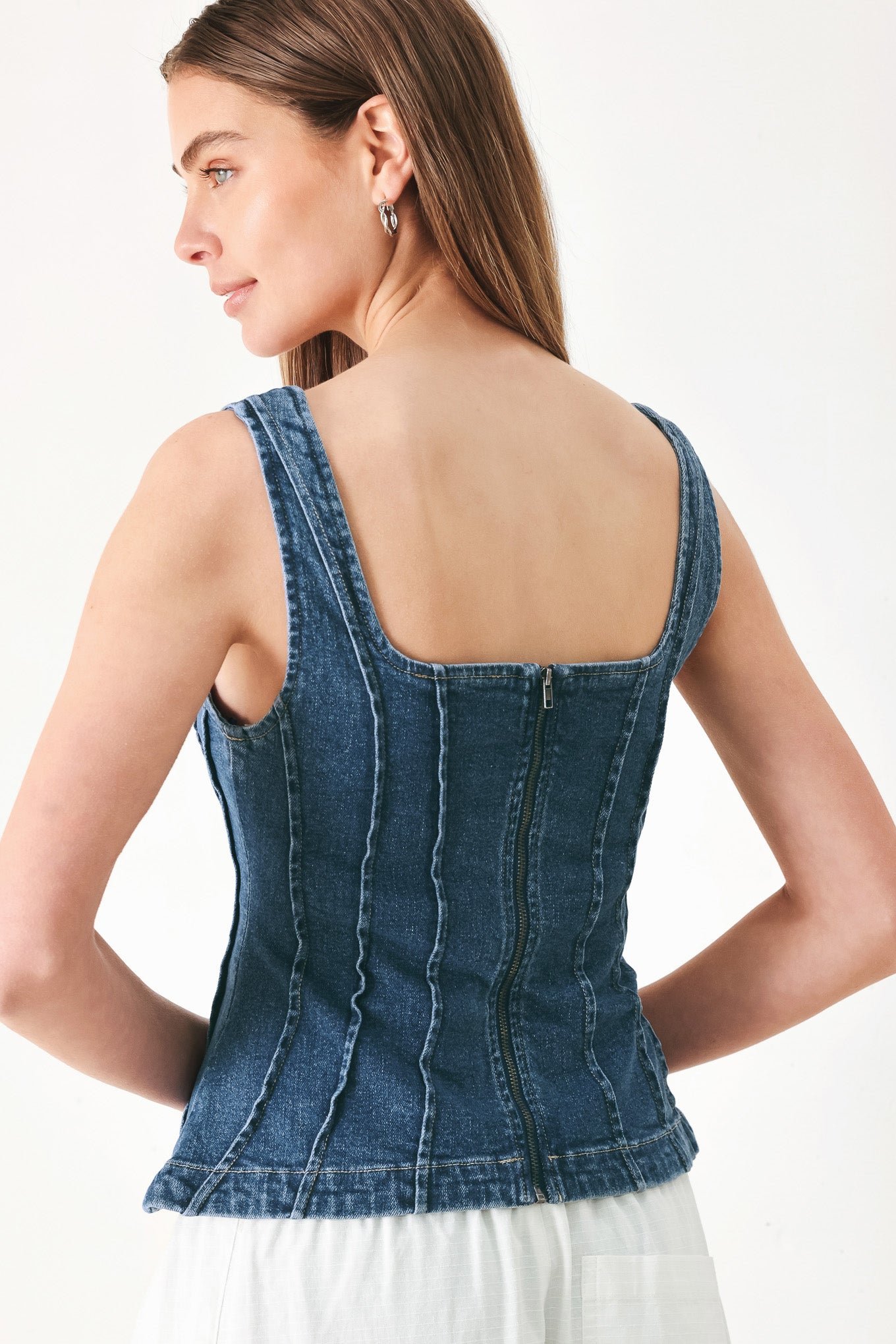 Woman wearing a sleeveless denim corset top with square neckline, peplum and back zipper closure | FREEMARKET | Flying Tomato