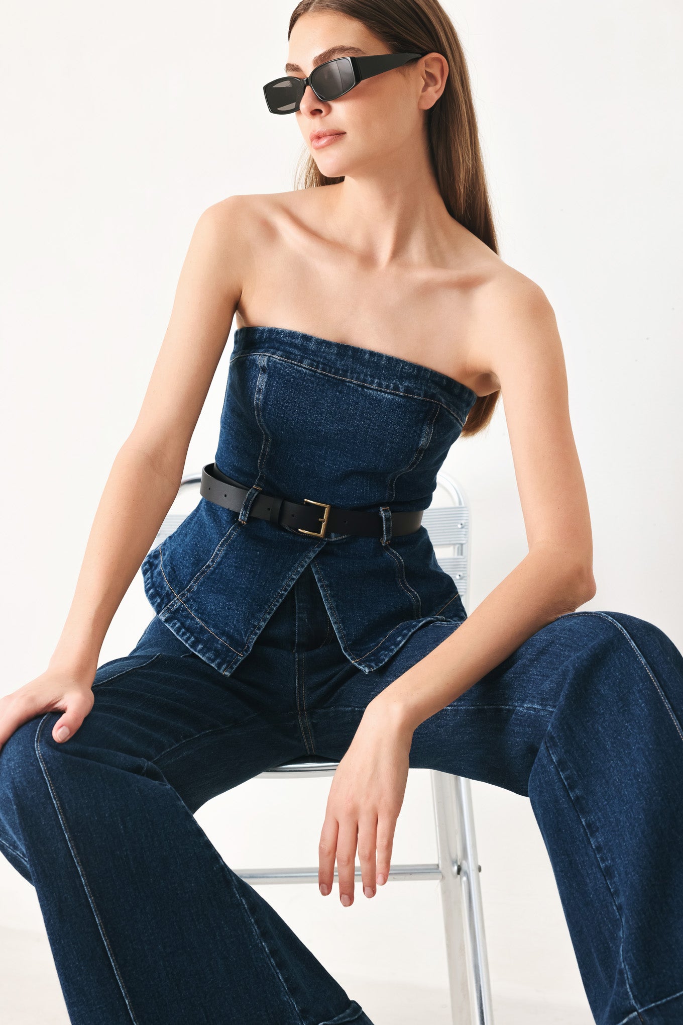 Woman wearing a strapless denim denim tube top featuring contrasting belt, front slit peplum and back zipper closure | FREEMARKET | Flying Tomato