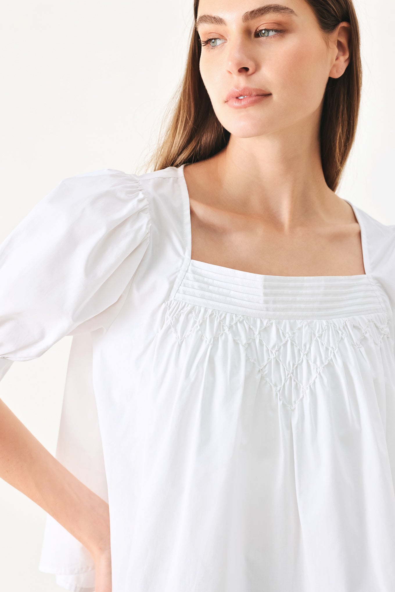 Woman wearing a white blouse featuring square neckline, elbow sleeve with cuff and back button closure | Flying Tomato