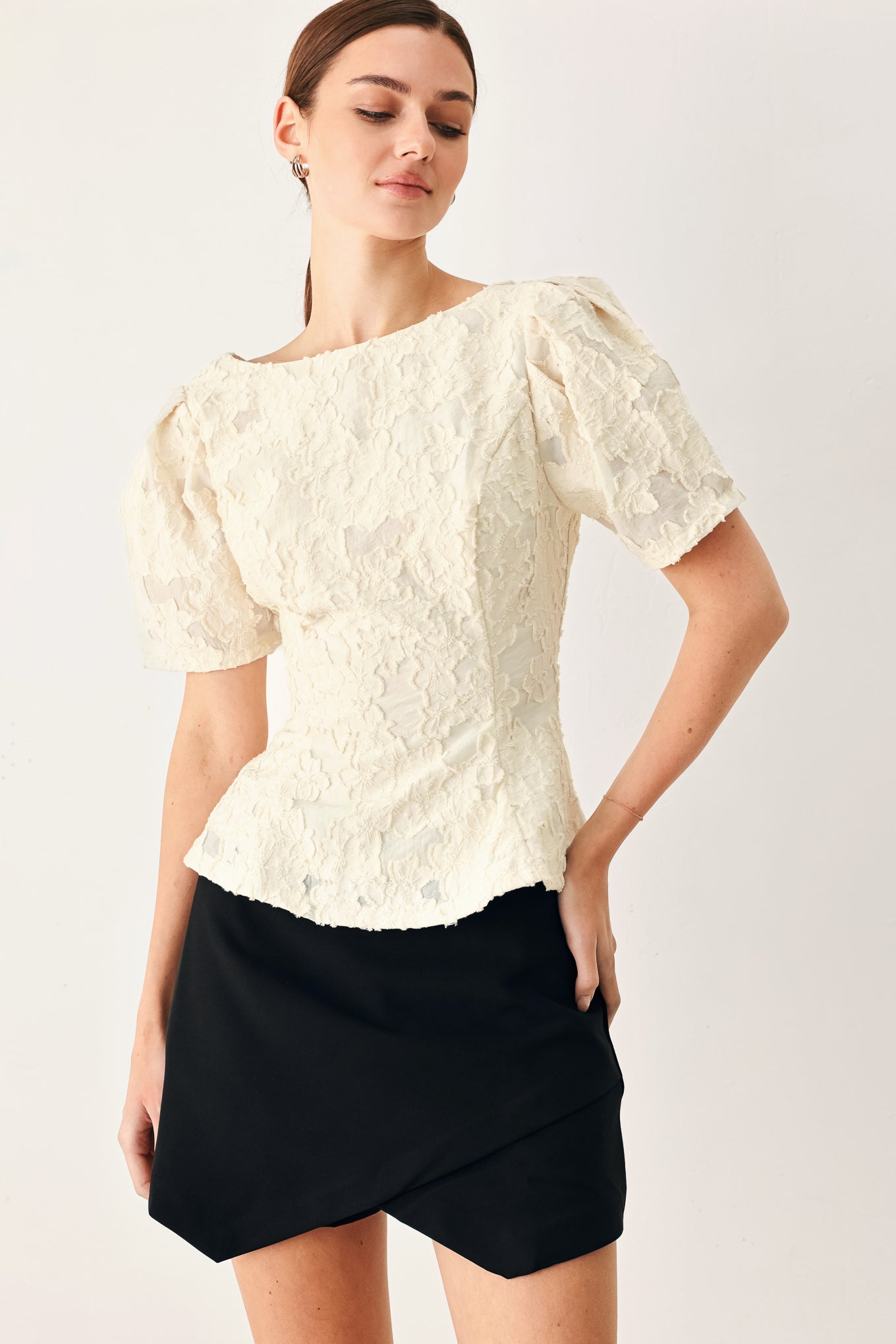 Woman wearing a white lace jacquard top featuring round neckline, short sleeve, peplum and V back with zipper closure | FREEMARKET