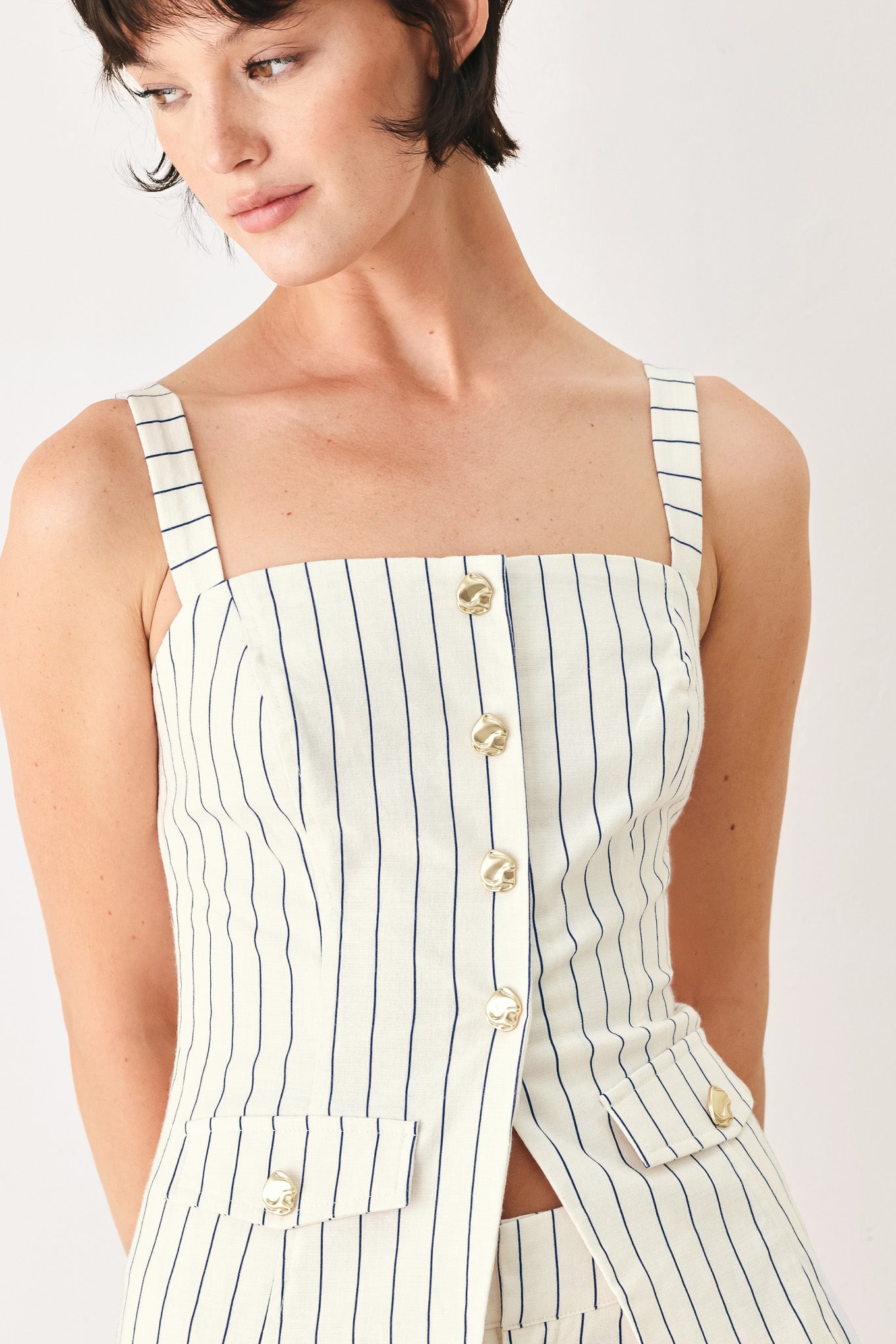 Woman wearing a top with navy pinstripes and gold buttons | FREEMARKET