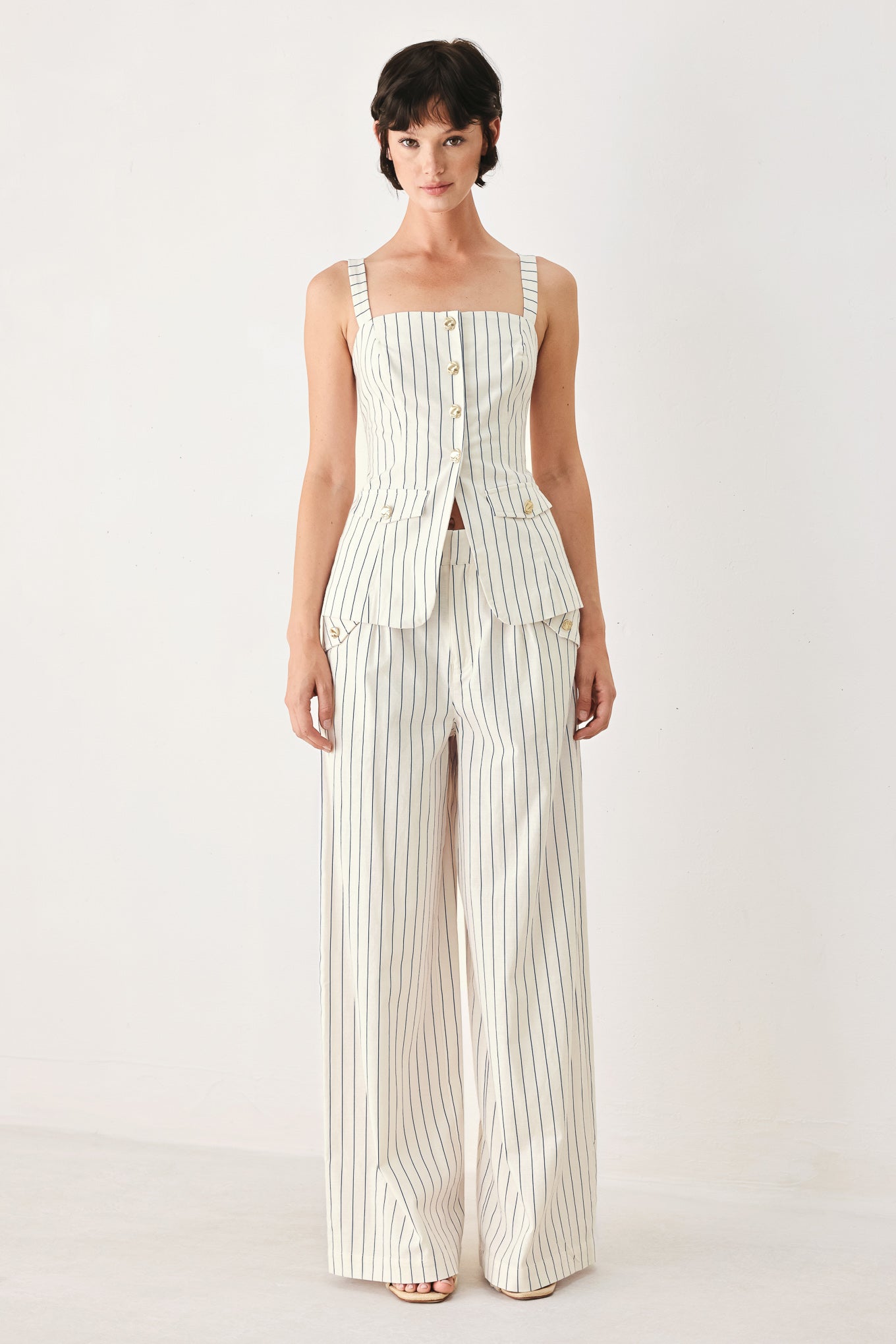 Woman wearing a top with navy pinstripes and gold buttons | FREEMARKET