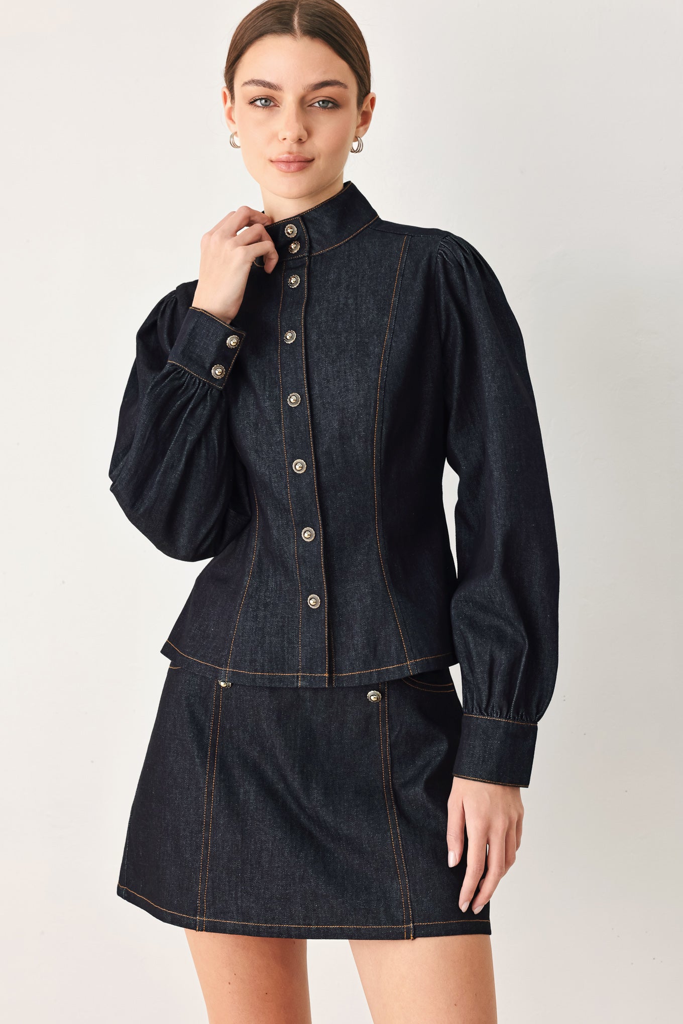 Woman wearing lightweight dark denim top with high neckline, long sleeve, front button down and peplum | FREEMARKET