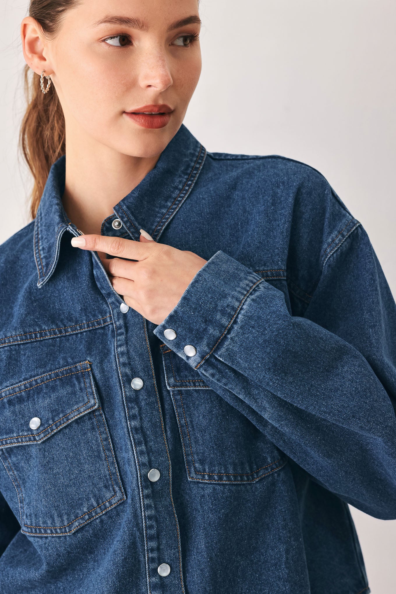 A woman wearing a dark blue denim button-up shirt jacket with two chest pockets | FREEMARKET