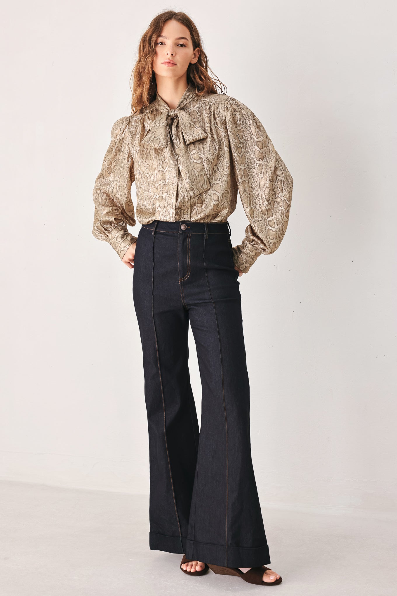 A woman modeling a long-sleeve brown and gold snake-patterned blouse with a tie-neck detail | FREEMARKET