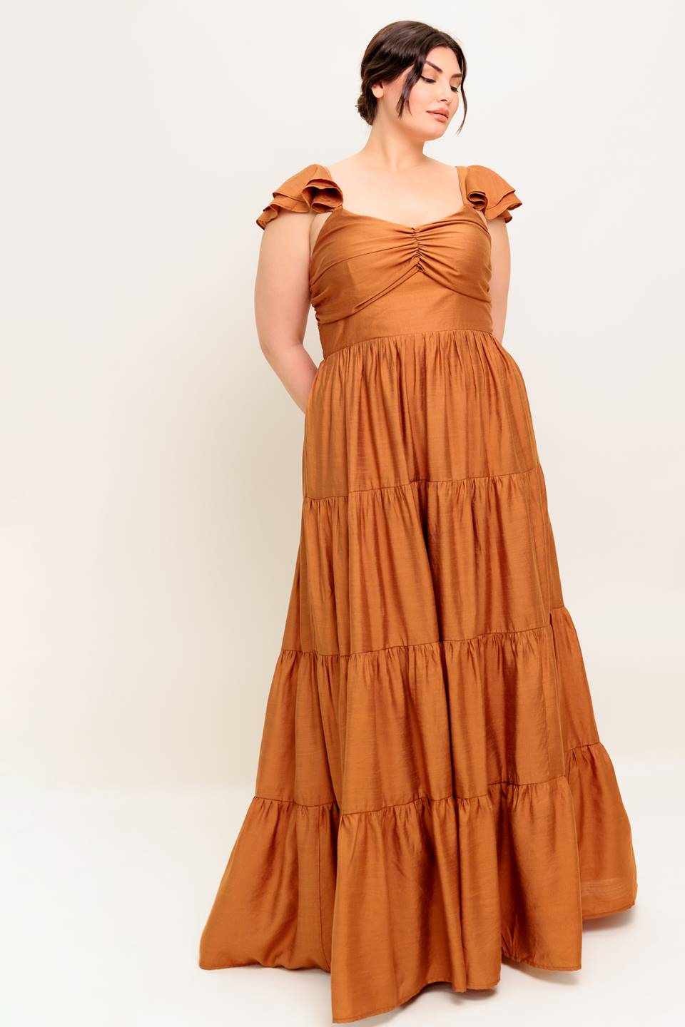 A solid woven maxi dress featuring cami top with layered sleeve, cinched front bodice, tiered skirt and smocked back bodice.