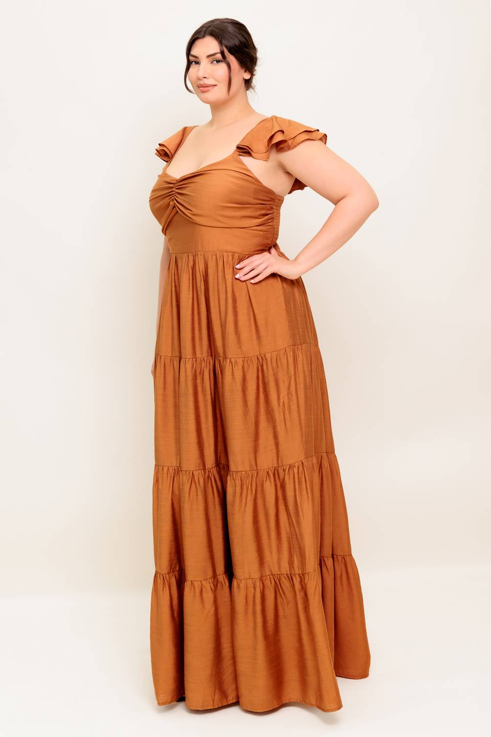 A solid woven maxi dress featuring cami top with layered sleeve, cinched front bodice, tiered skirt and smocked back bodice.