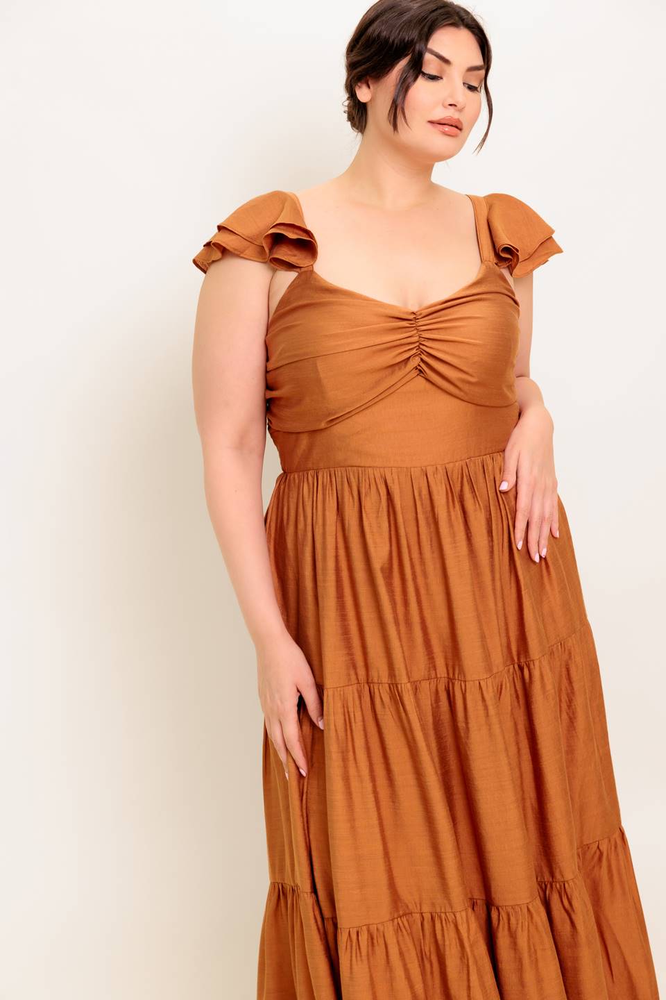 A solid woven maxi dress featuring cami top with layered sleeve, cinched front bodice, tiered skirt and smocked back bodice.