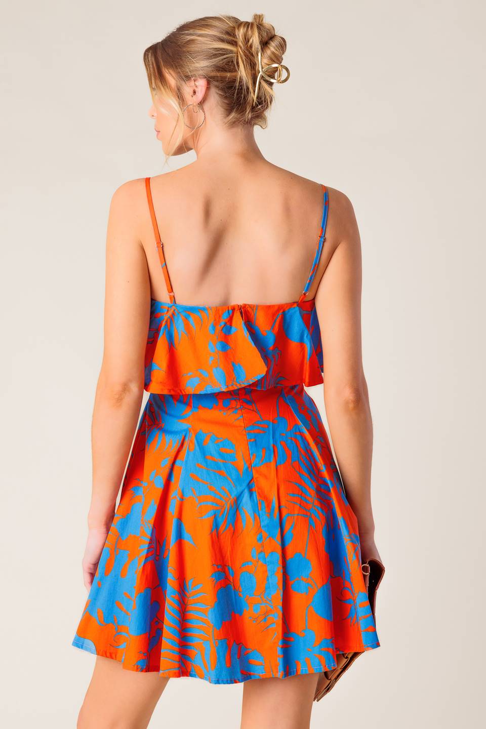 A printed woven mini dress featuring straight neckline, straps, flounce, full skirt and back zipper closure