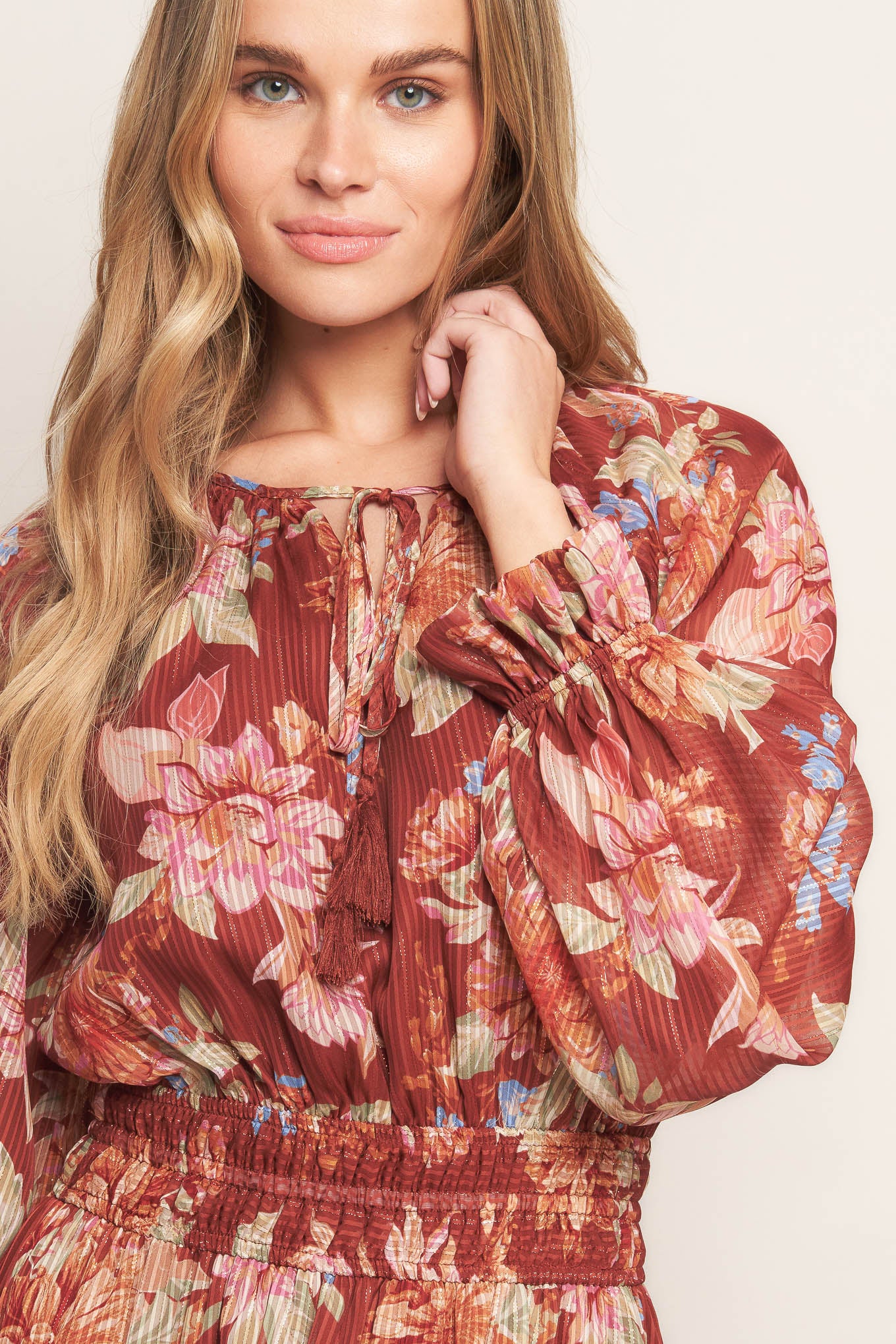 A printed woven midi dress featuring round neckline with front tie, long sleeve, elasticized waist and tiered skirt