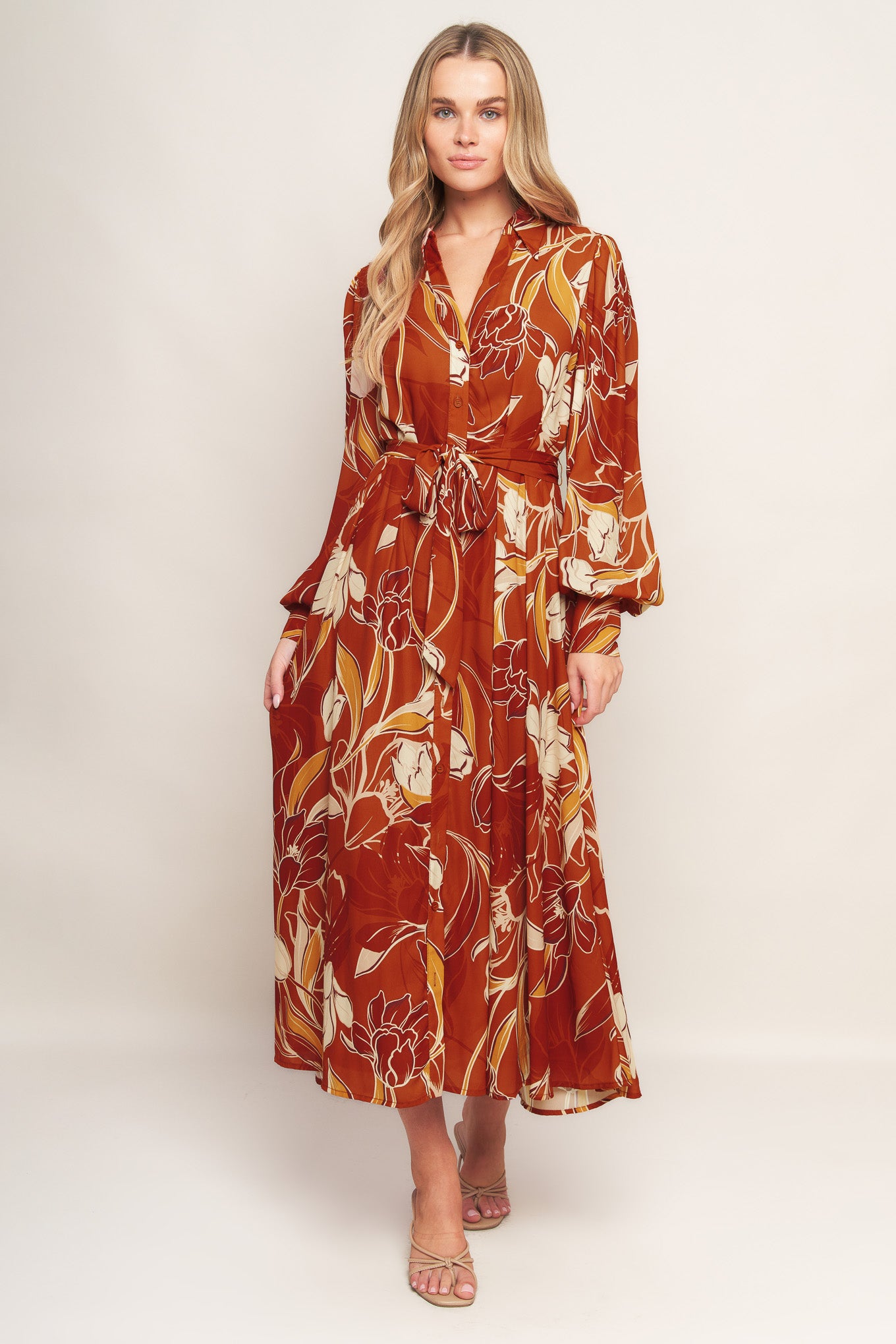 A printed woven midi dress featuring shirt collar, V neckline, long sleeves, button down, self sash tie and full skirt