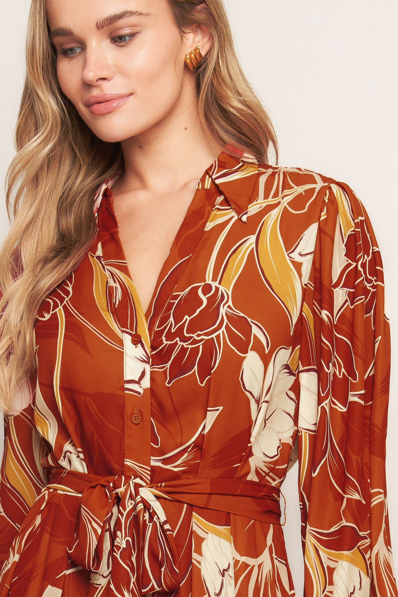 A printed woven midi dress featuring shirt collar, V neckline, long sleeves, button down, self sash tie and full skirt