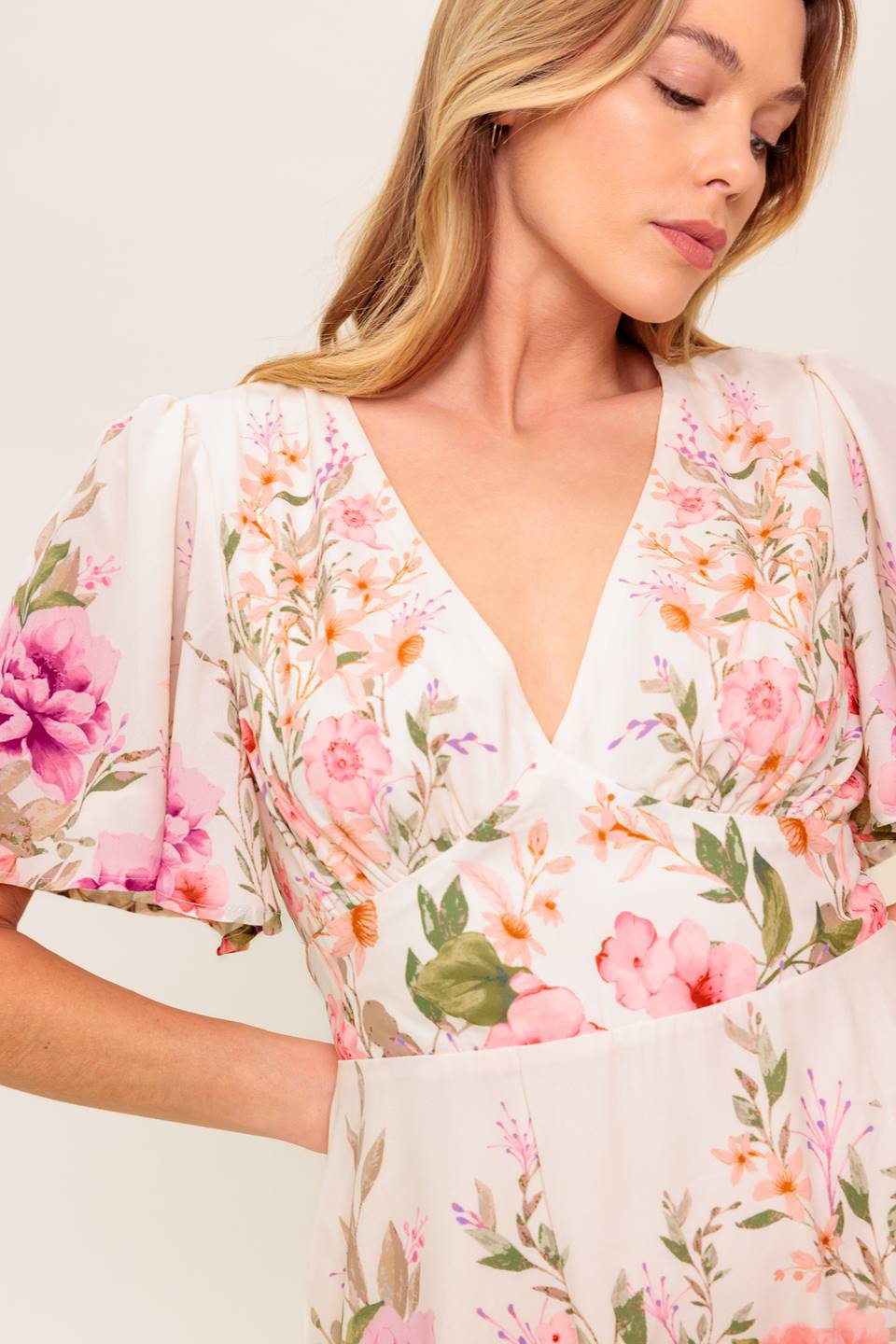 A printed woven mini dress featuring V neckline, long sleeve, waist yoke, ruffled hemline and back zipper closure