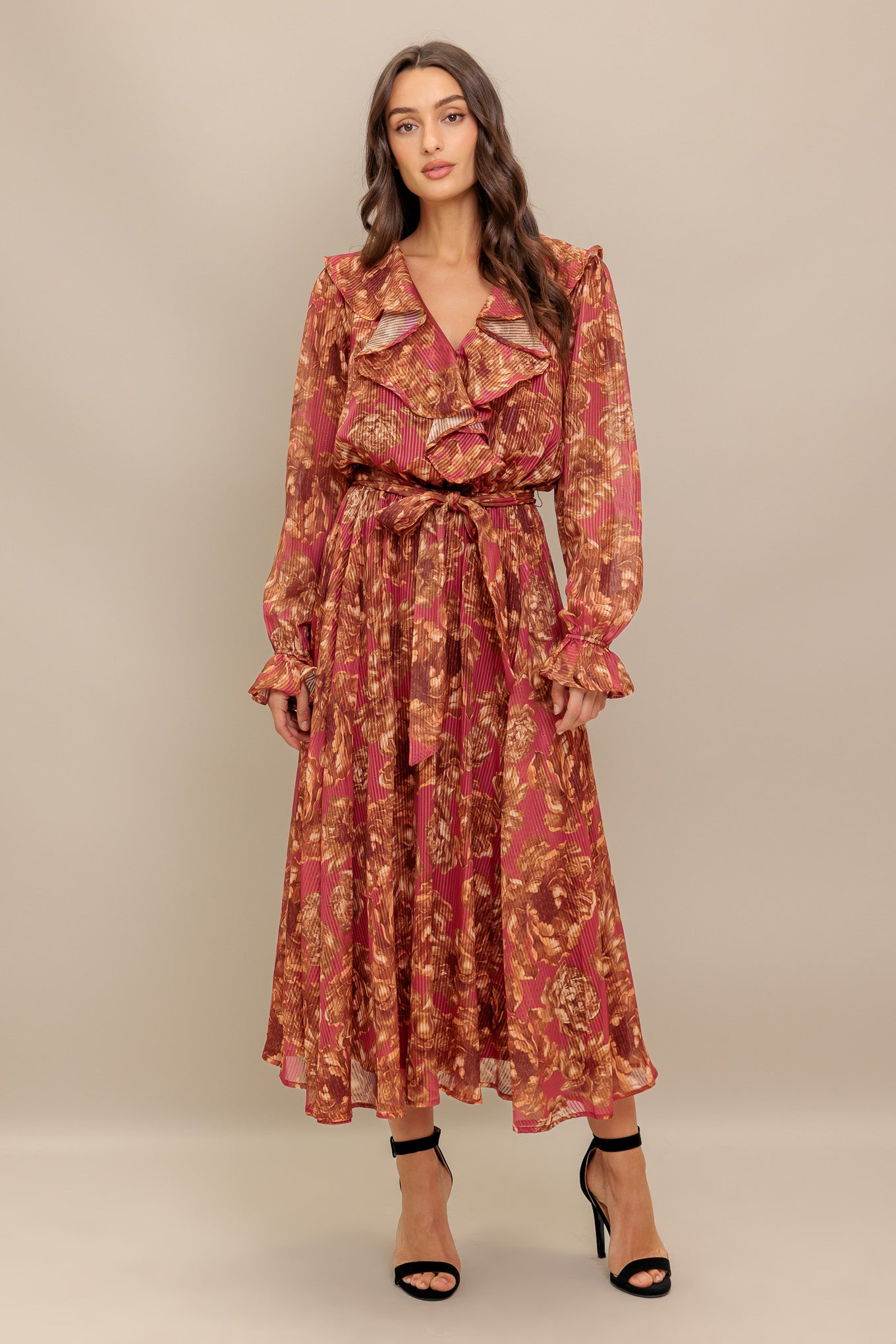 A printed woven midi dress featuring surplice neckline with ruffles, long sleeve with ruffled cuff, elasticized waist with self sash tie and full skirt