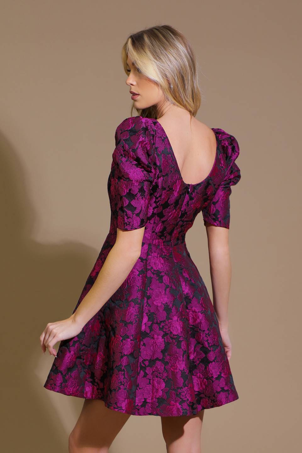 A woman wearing a purple floral jacquard mini dress with a wide neckline, puff sleeves, and a full skirt. - Flying Tomato