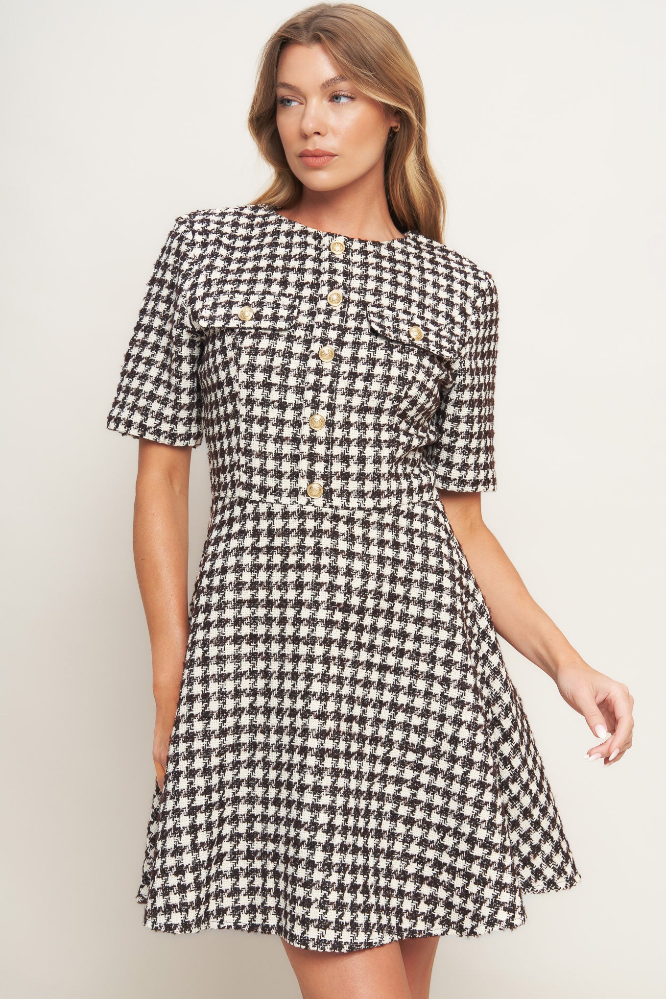 A tweed mini dress featuring round neckline, short sleeve, front button detail, A line skirt and back zipper closure