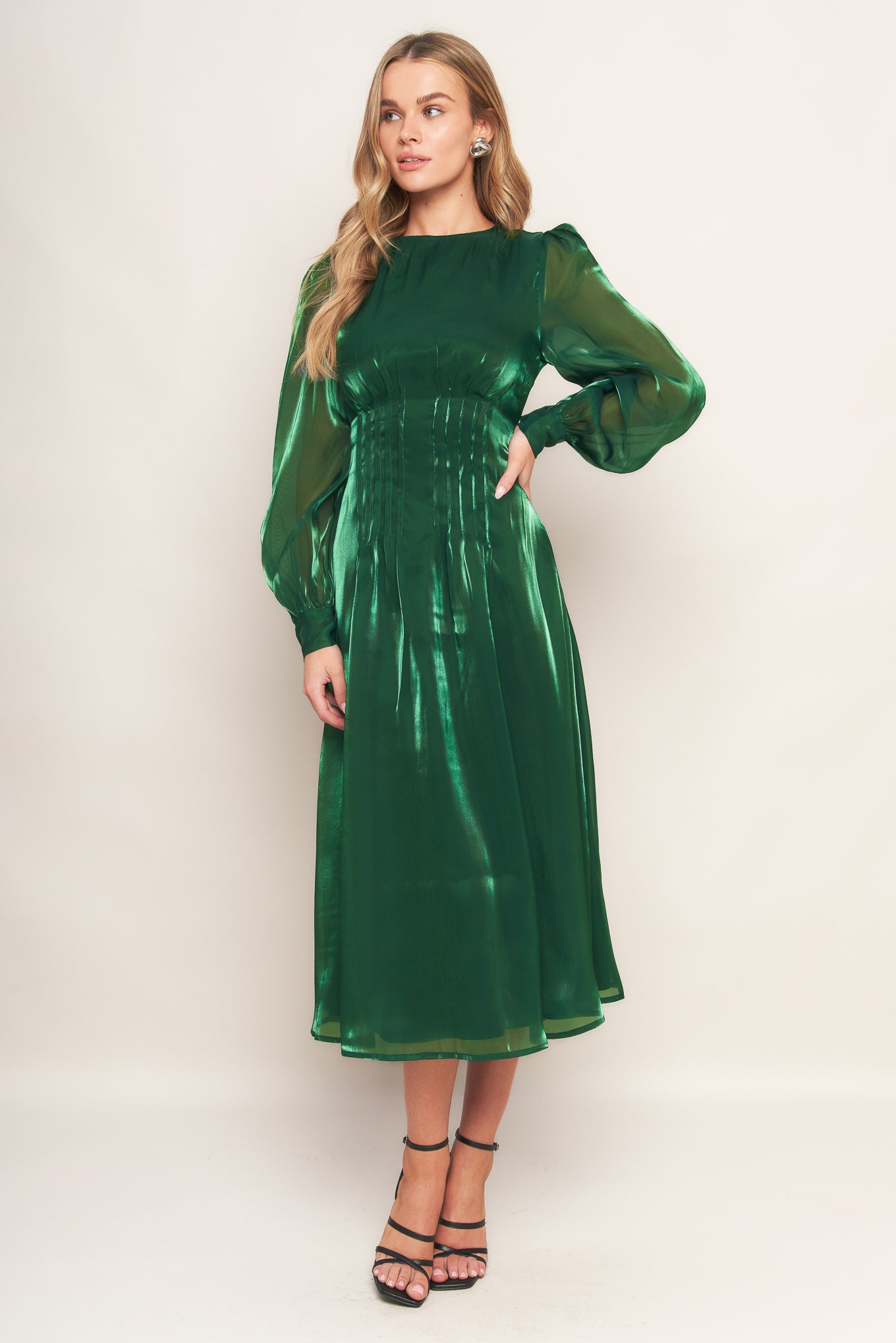 A solid woven midi dress featuring round neckline, long sleeve, cinching detail at waist and back zipper closure