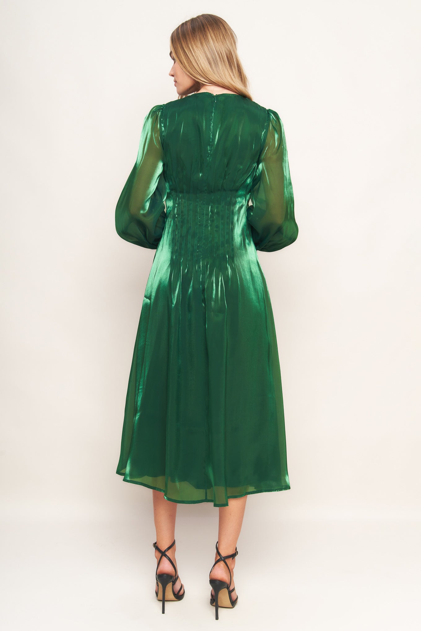 A solid woven midi dress featuring round neckline, long sleeve, cinching detail at waist and back zipper closure