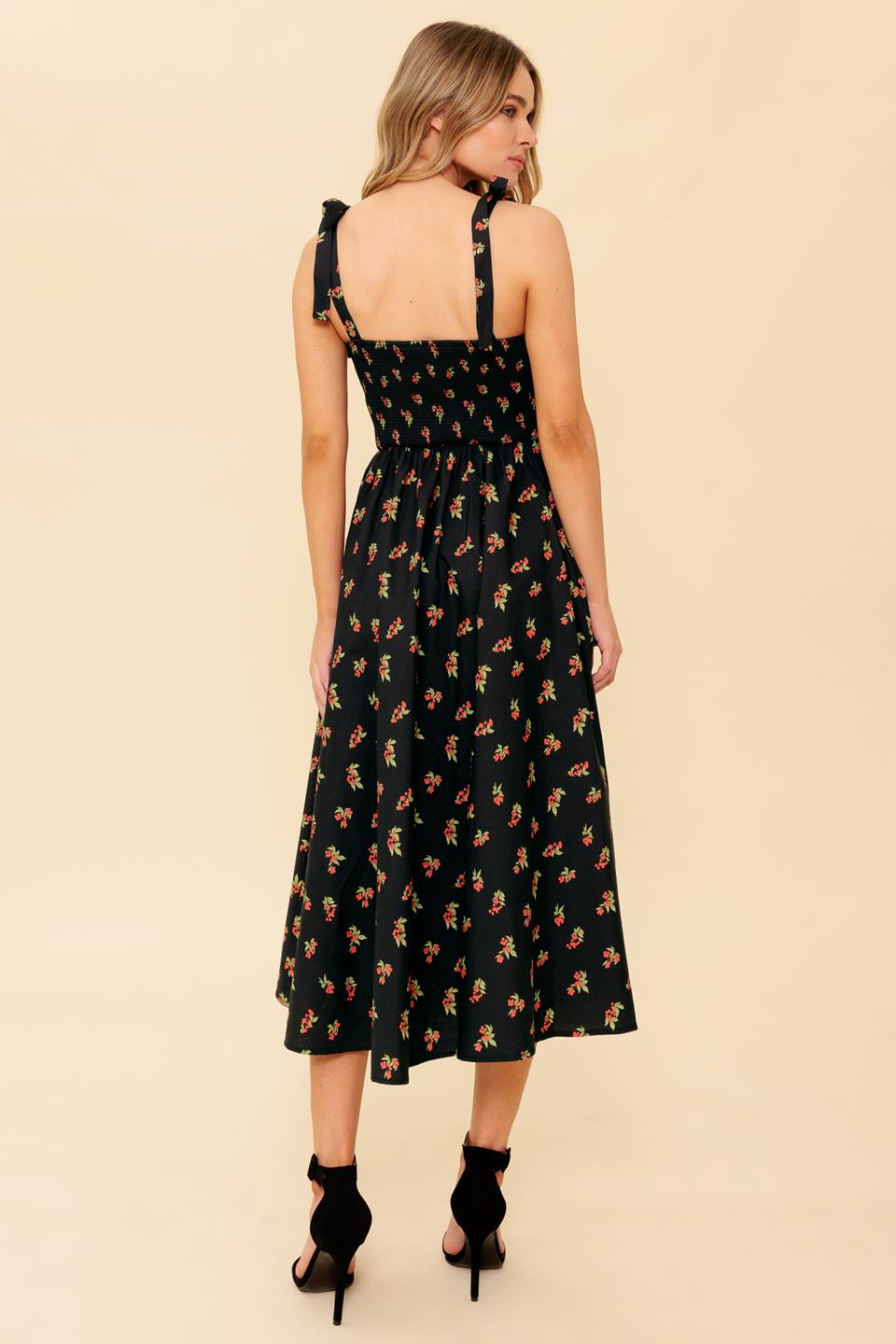 A printed woven midi dress featuring bustier top, shoulder tie, full skirt and smocked back bodice.