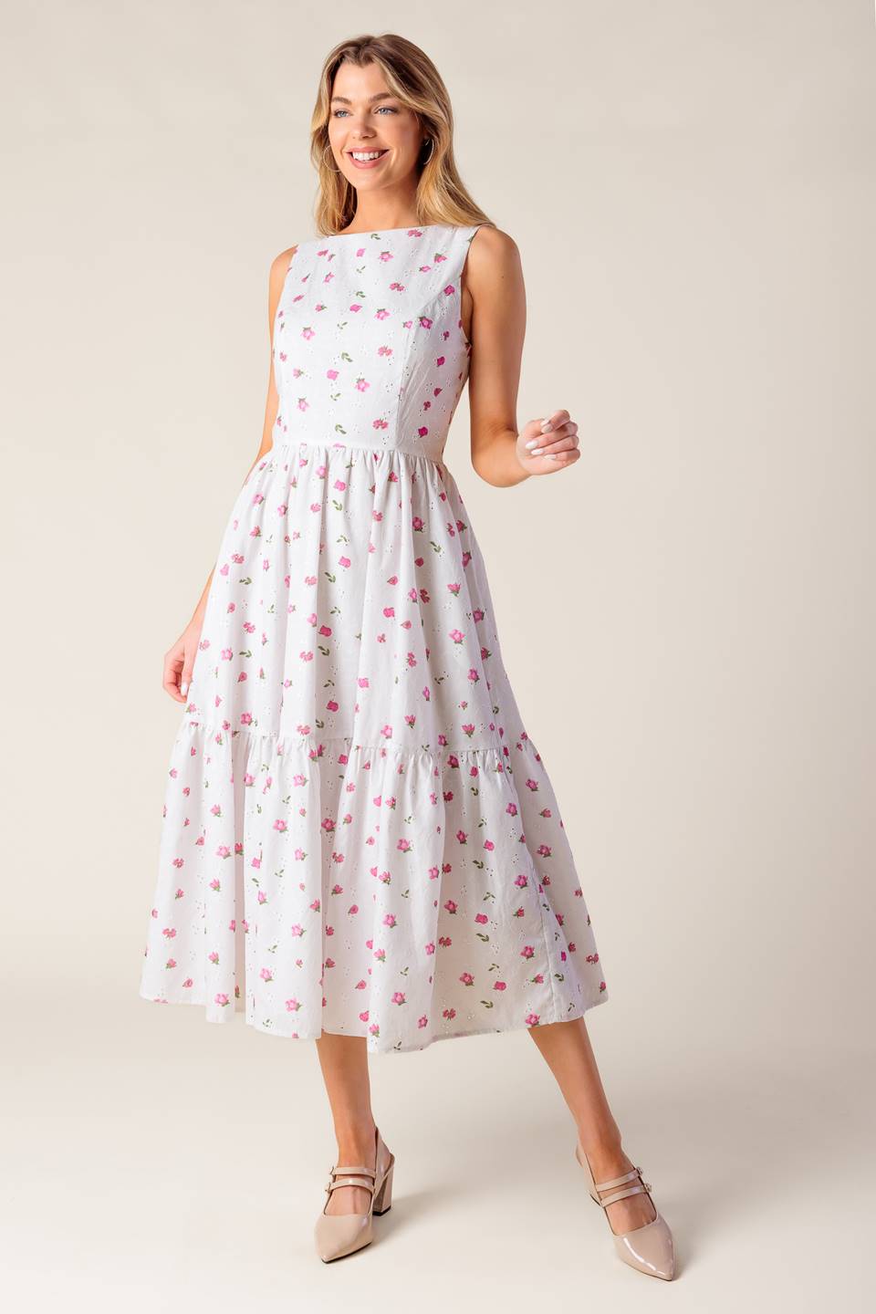 A printed woven eyelet midi dress featuring round neckline, sleeveless, ruffled hem, U back with tie and zipper closure