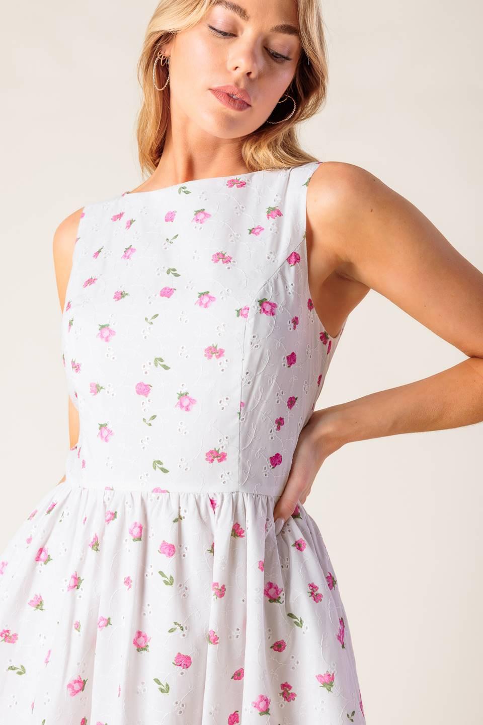 A printed woven eyelet midi dress featuring round neckline, sleeveless, ruffled hem, U back with tie and zipper closure