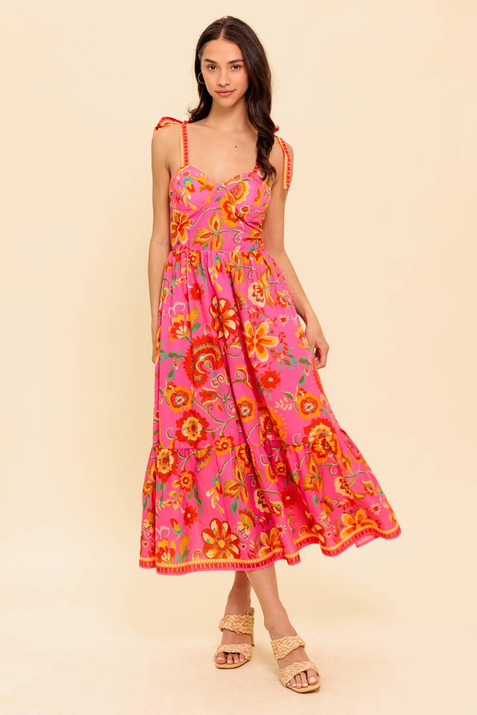 A printed woven midi dress featuring bustier top with shoulder tie, full skirt with ruffled hemline and smocked back bodice