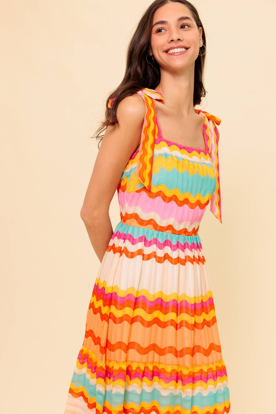 A printed woven maxi dress featuring straight neckline, shoulder ties, tiered skirt and back zipper closure