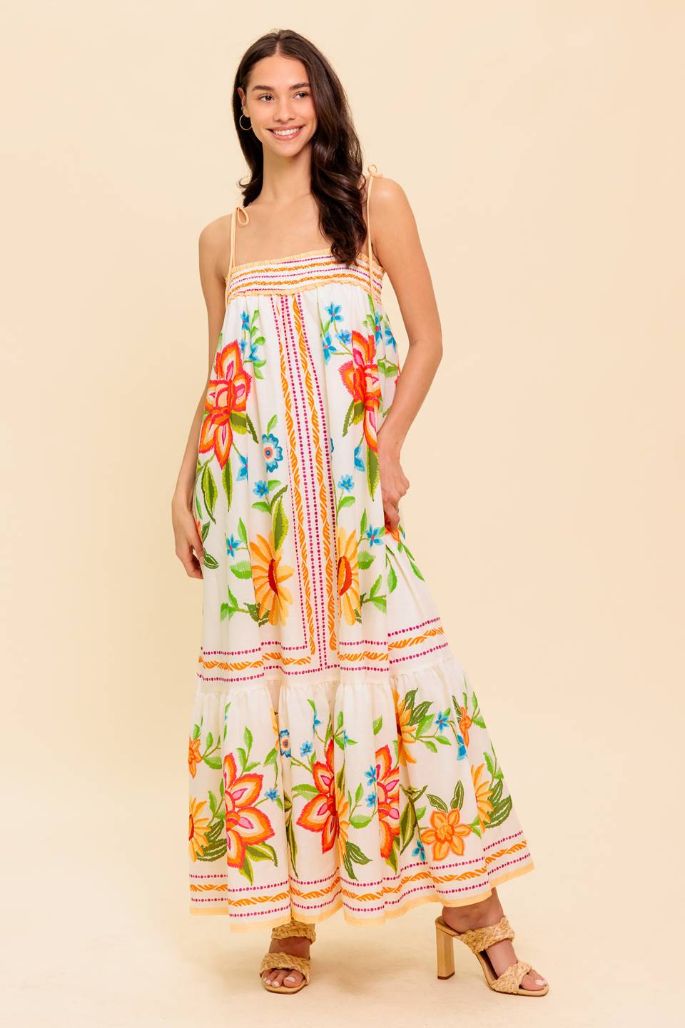 A printed woven maxi dress featuring straight neckline with smocked band, shoulder tie, ruffled hemline and back cut out