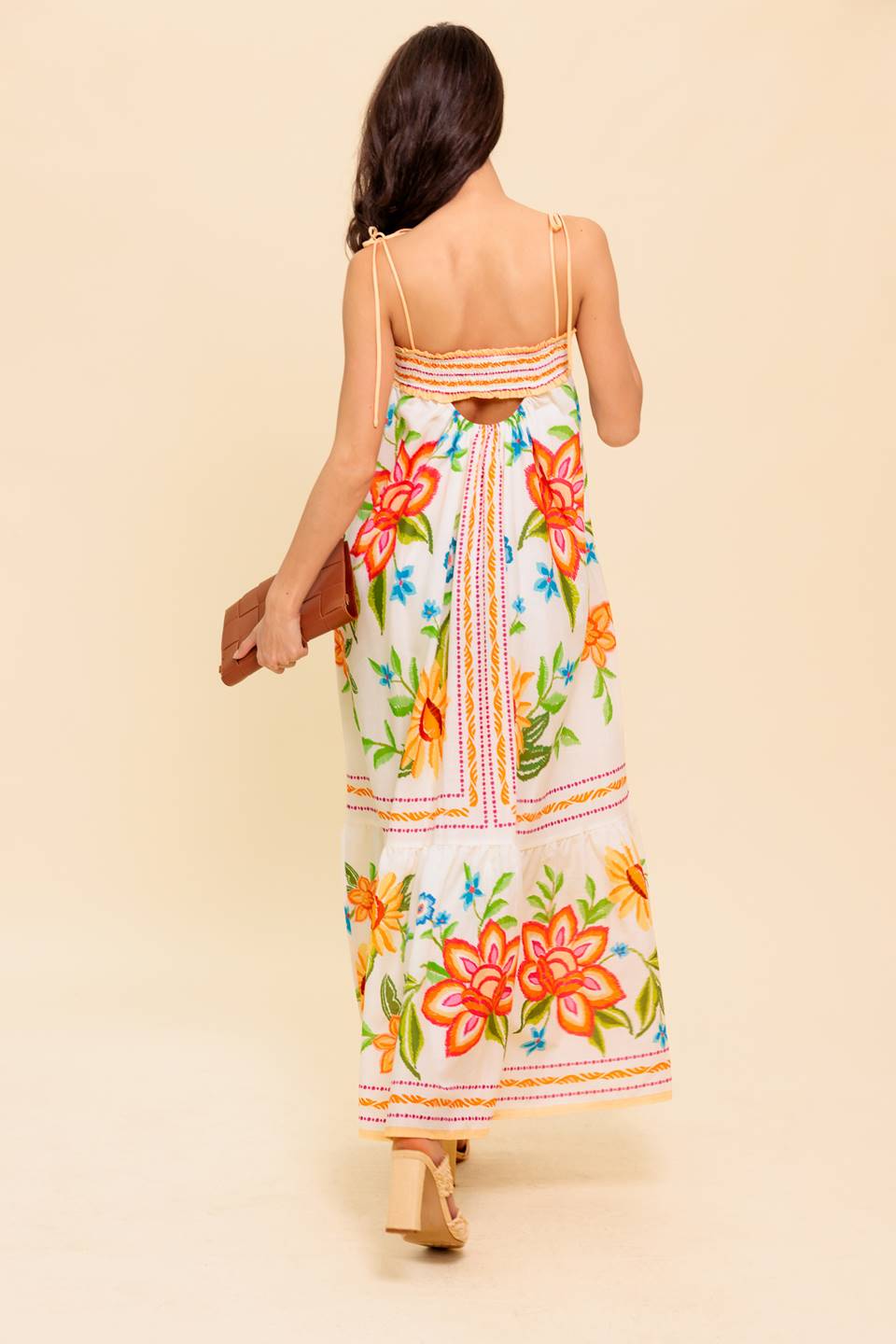 A printed woven maxi dress featuring straight neckline with smocked band, shoulder tie, ruffled hemline and back cut out