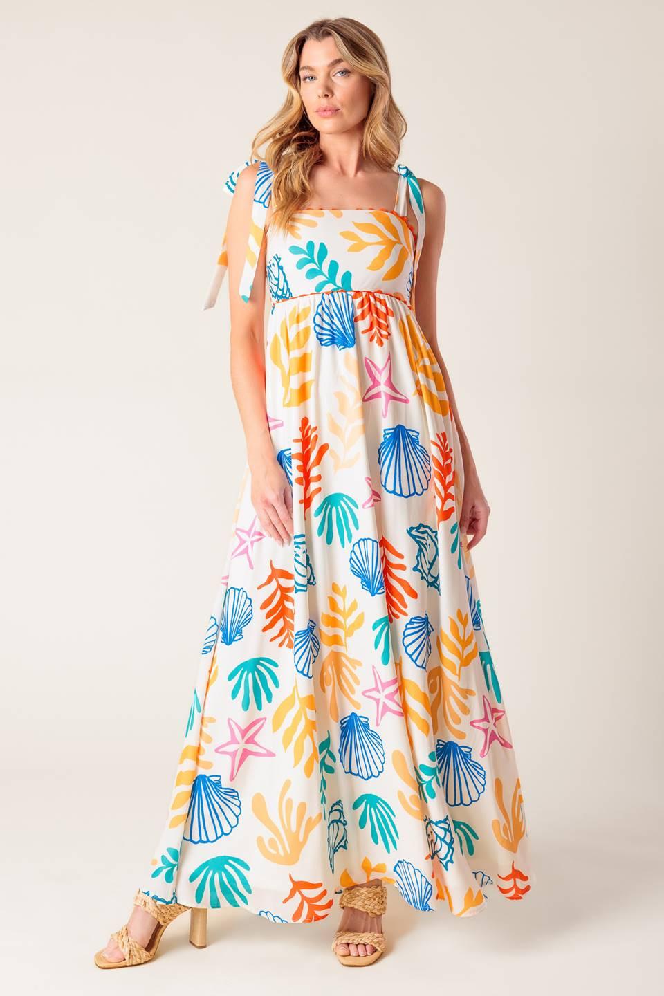 A printed woven maxi dress featuring straight neckline with ribbon edge, shoulder ties and smocked back bodice.