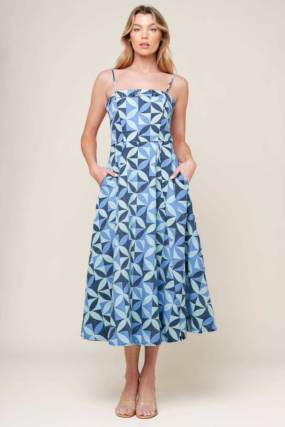 A printed denim midi dress featuring straight neckline, straps, full skirt and back zipper closure.