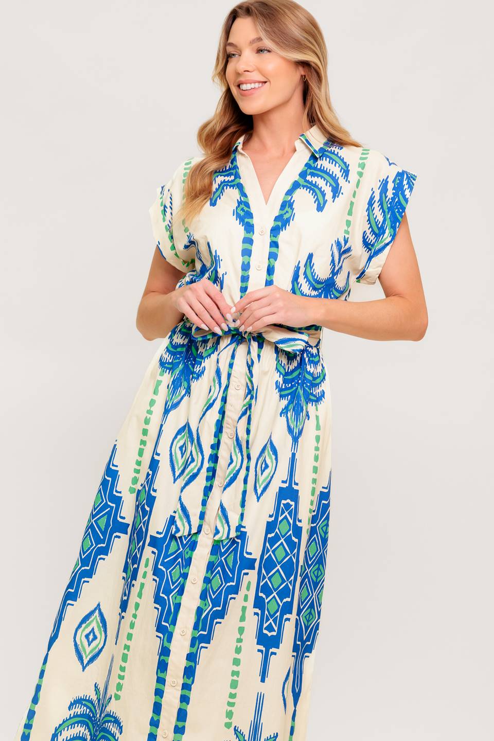 A printed woven midi dress featuring collar, V neckline, short sleeve, button down and self sash tie.