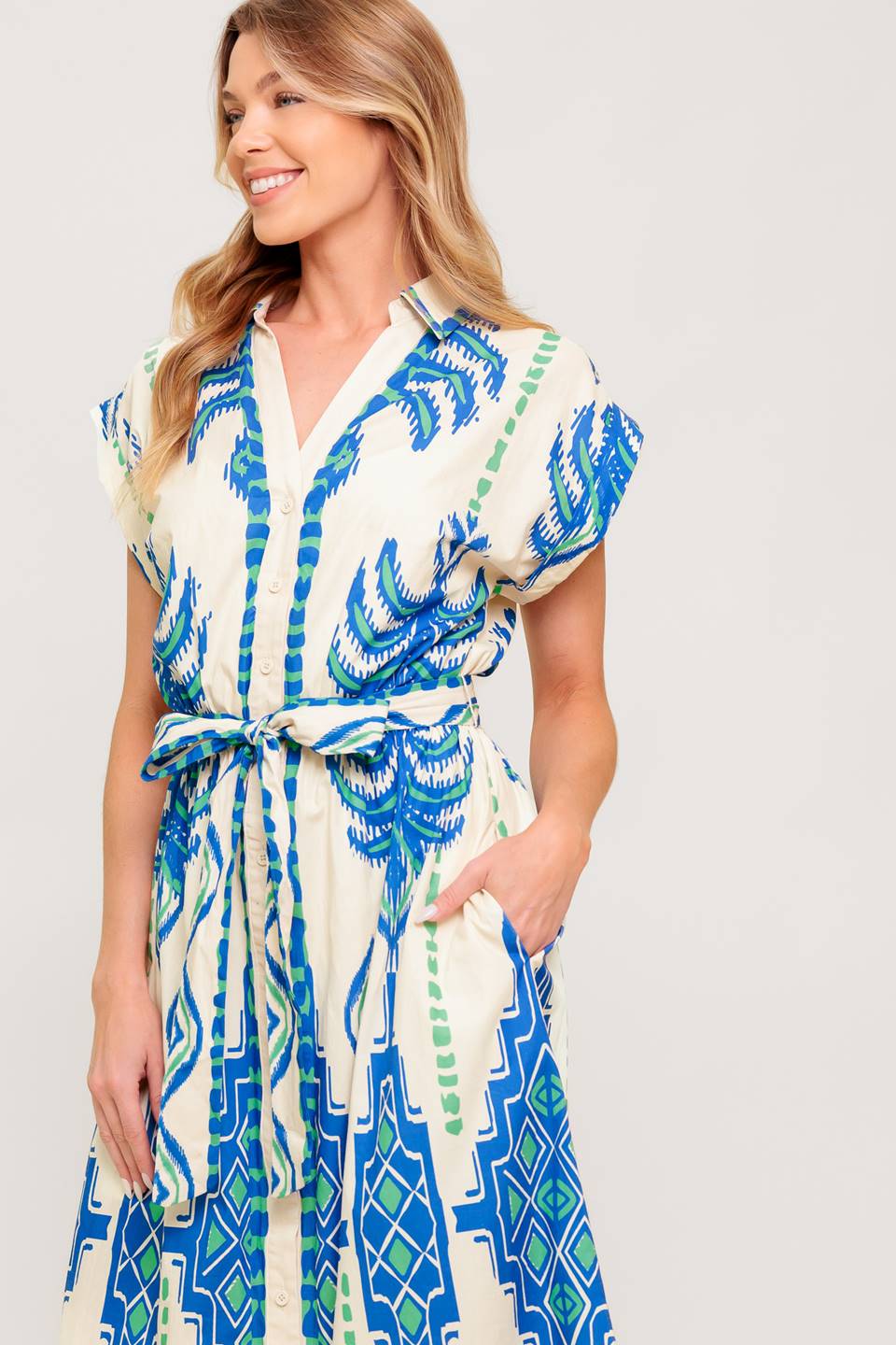 A printed woven midi dress featuring collar, V neckline, short sleeve, button down and self sash tie.