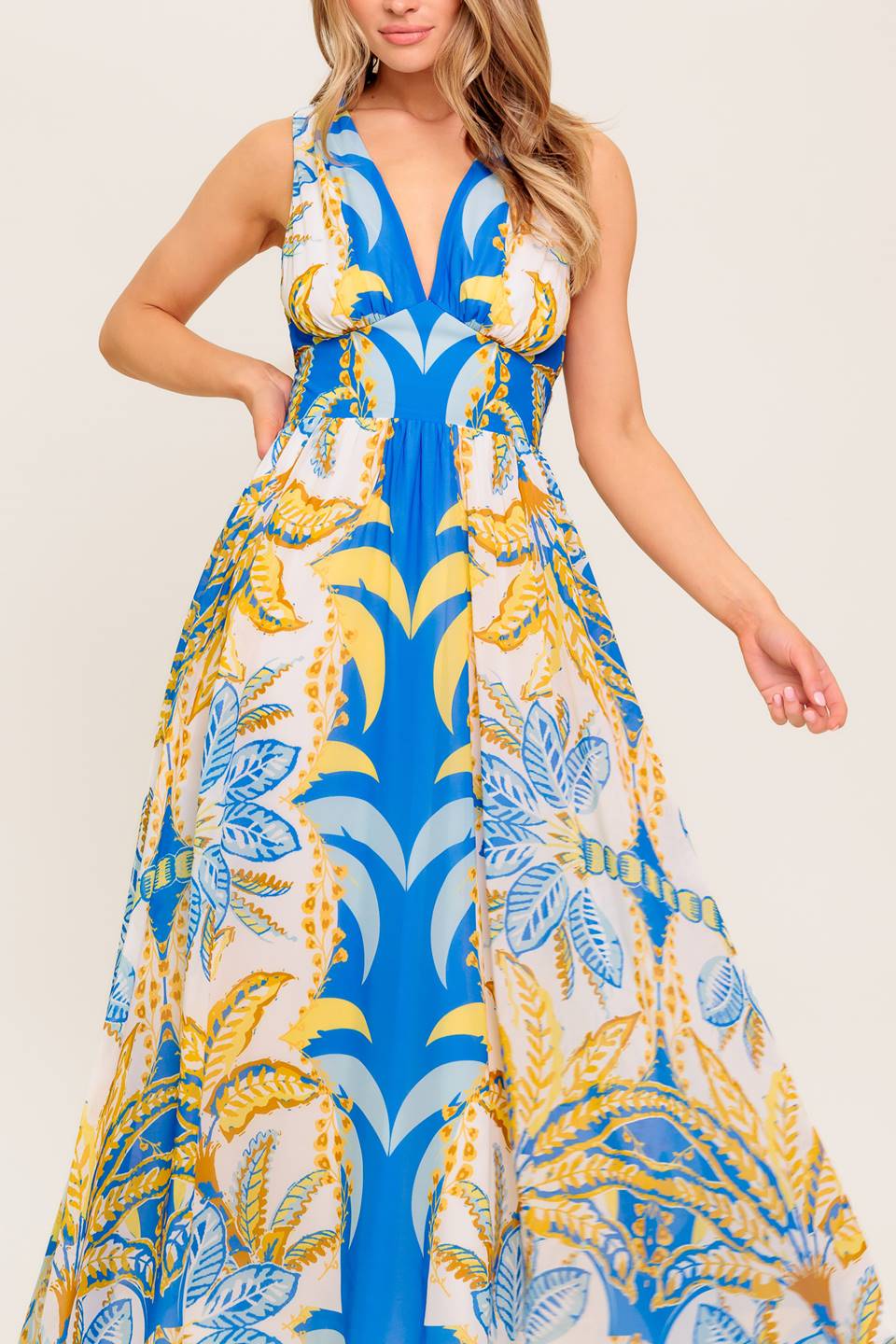 A printed woven midi dress featuring V neckline, sleeveless, waist yoke, full skirt and smocked back waistband.
