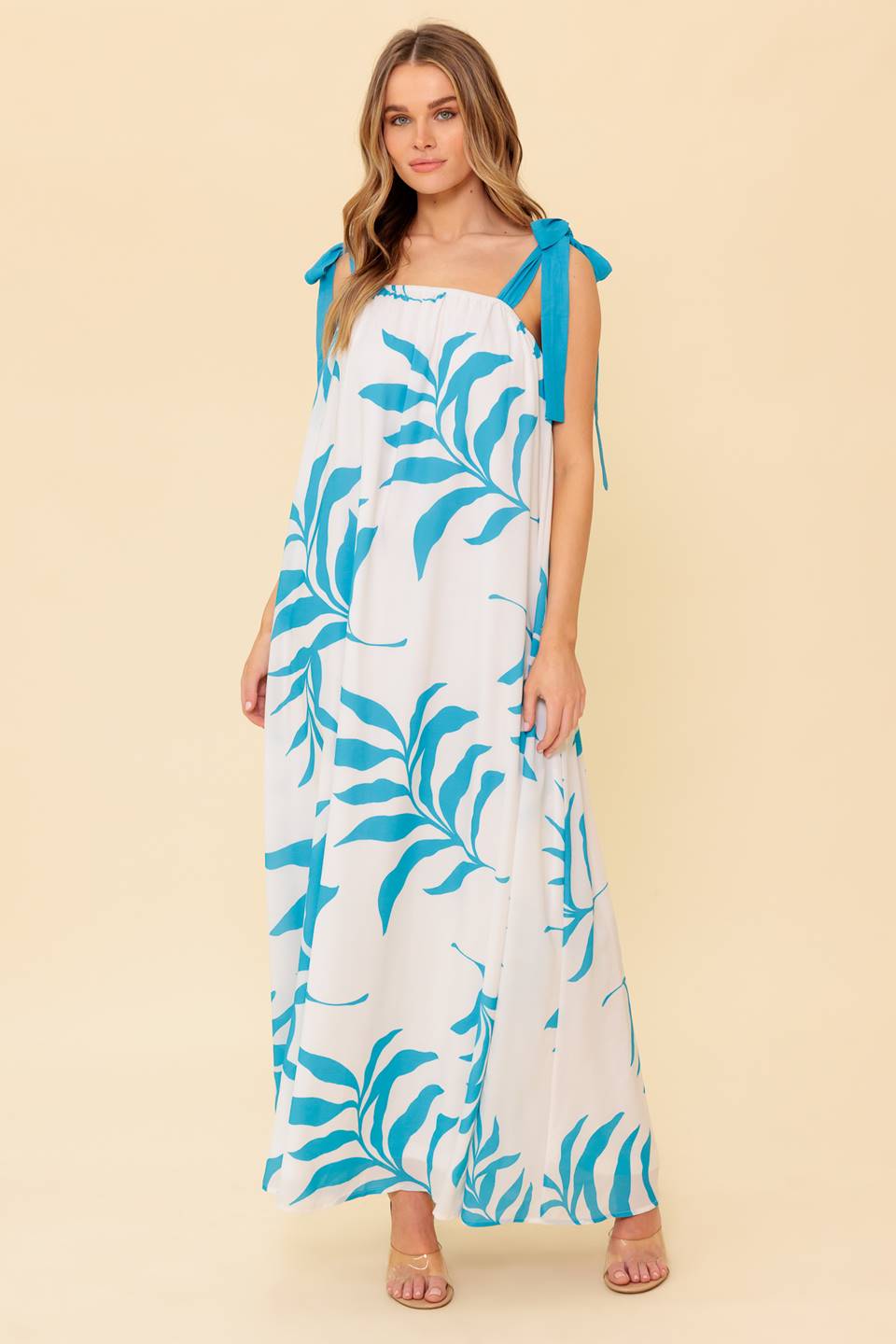 A printed woven maxi dress featuring straight neckline, shoulder tie and plunging back
