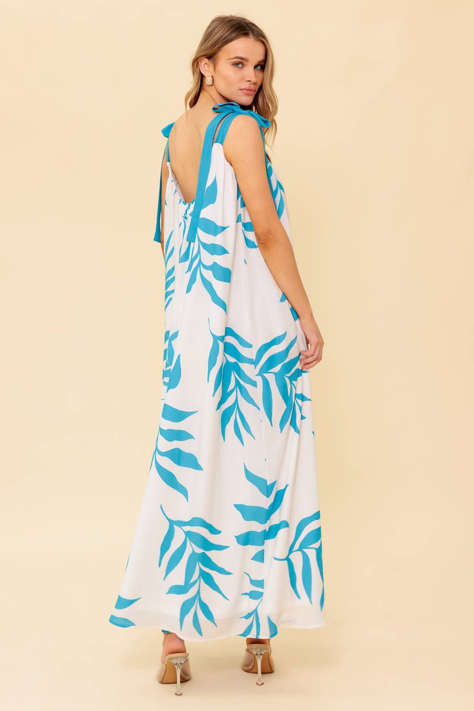 A printed woven maxi dress featuring straight neckline, shoulder tie and plunging back