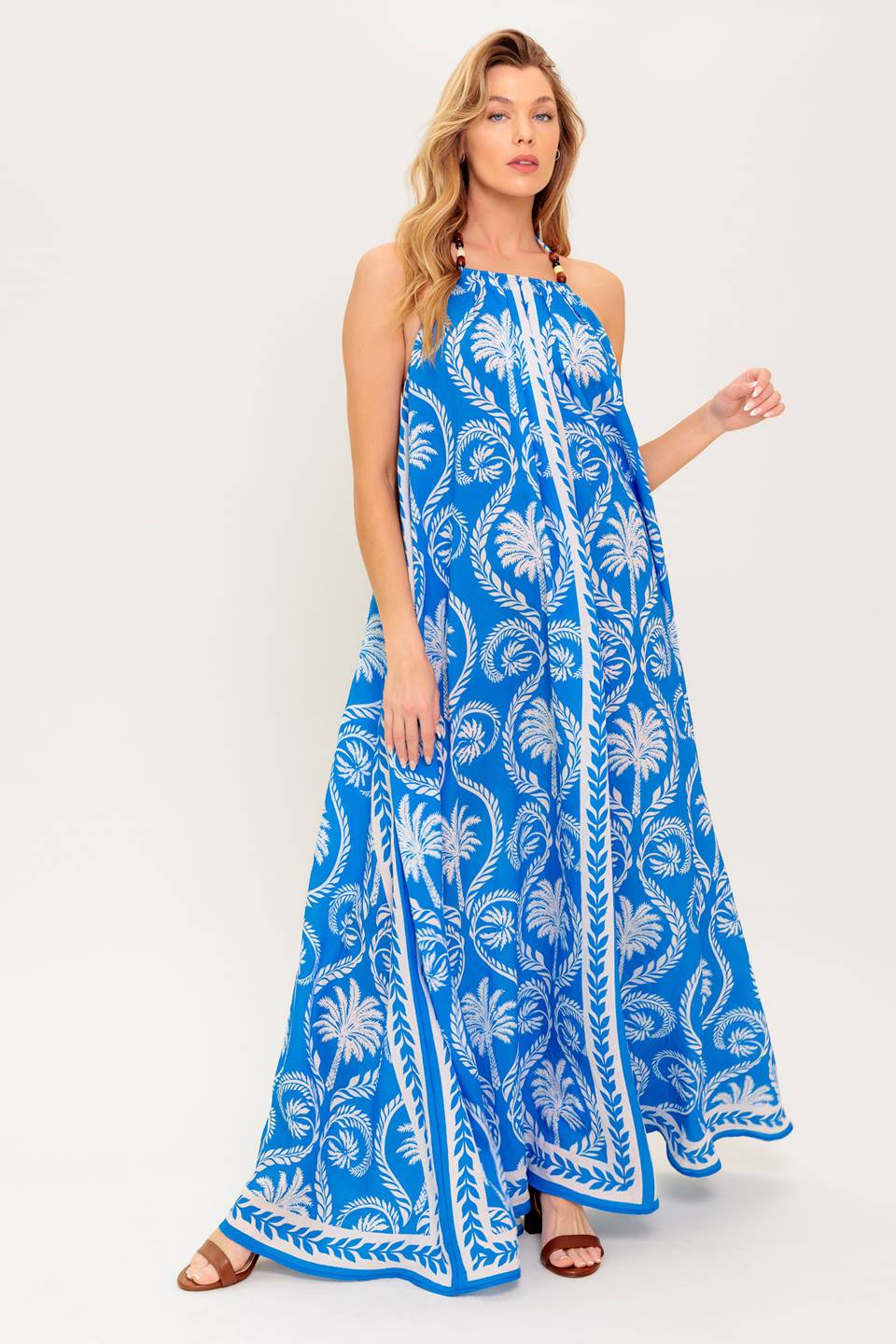 A printed woven maxi dress featuring halter neckline, trimmed tie and plunging back
