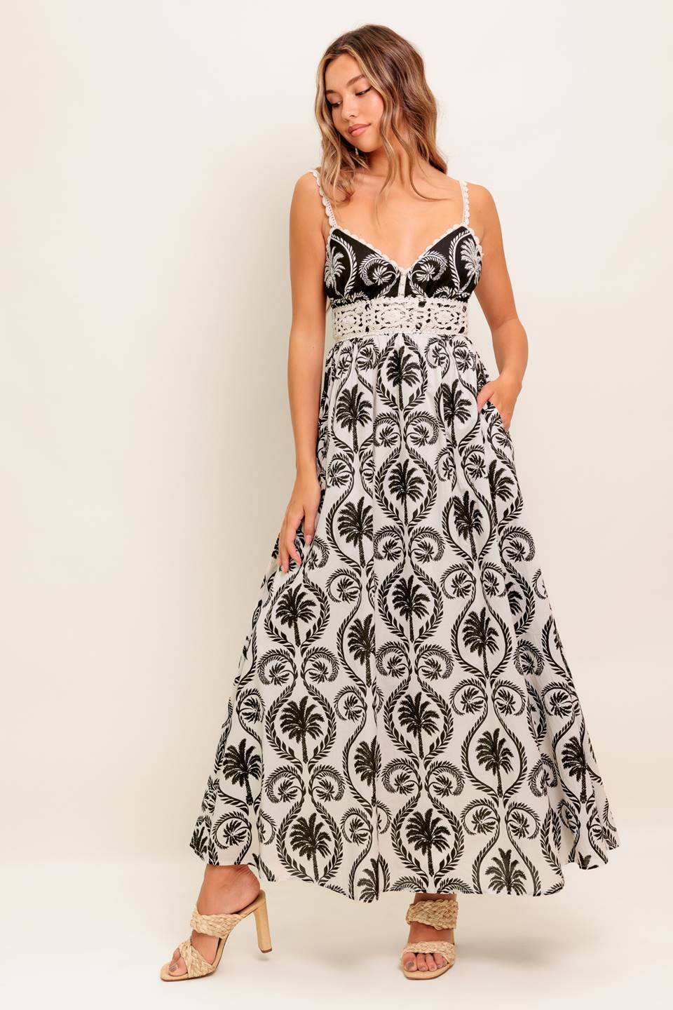 A printed woven maxi dress featuring cami top with crochet lace edge and waistband, full skirt and back zipper closure.