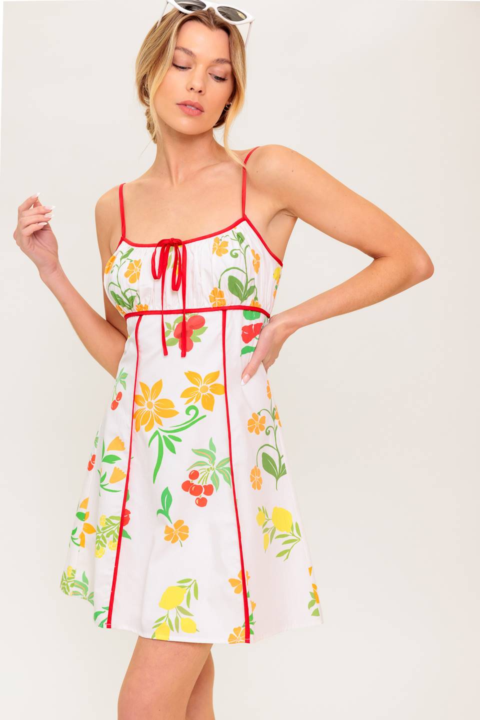 A printed woven mini dress featuring straight neckline, straps, shirred bust, A line skirt and back zipper closure