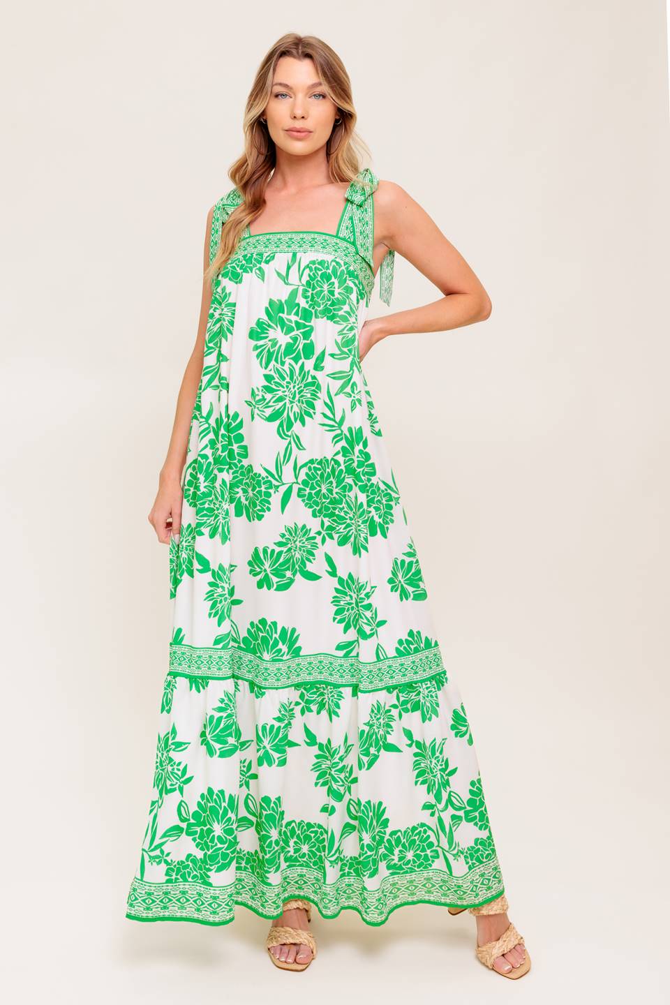 A printed woven maxi dress featuring straight neckline, shoulder tie and ruffled hemline