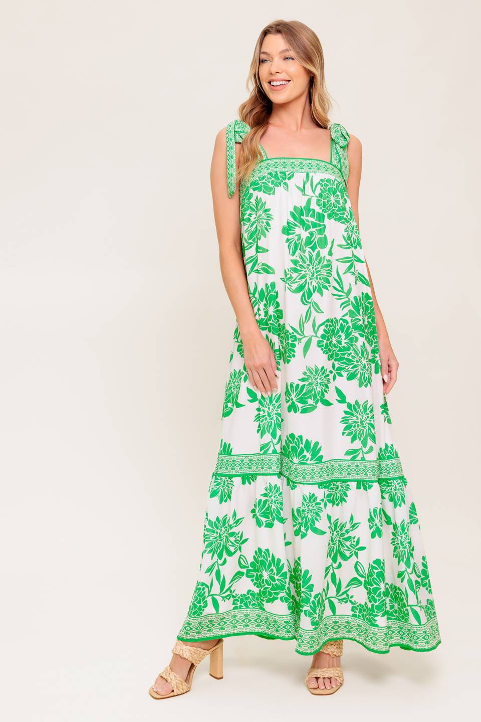A printed woven maxi dress featuring straight neckline, shoulder tie and ruffled hemline