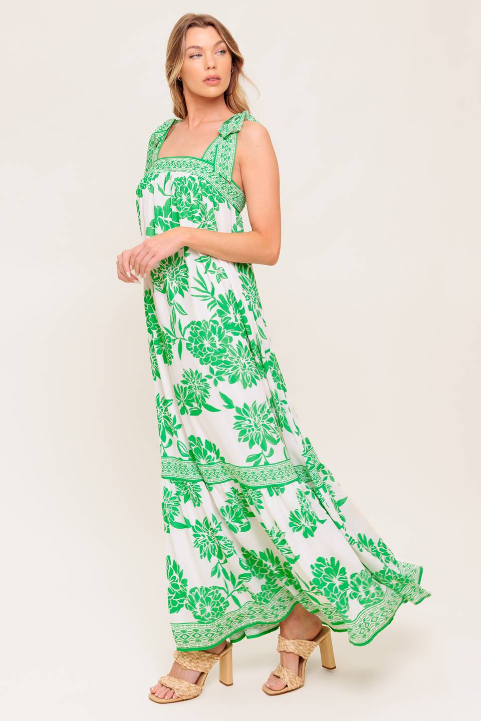 A printed woven maxi dress featuring straight neckline, shoulder tie and ruffled hemline