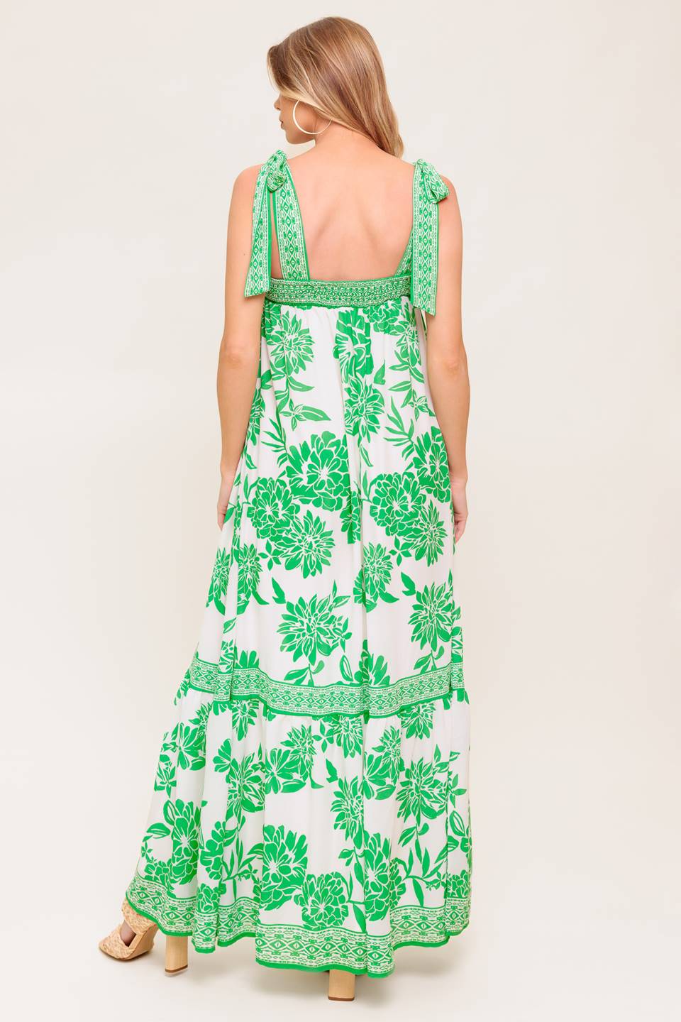 A printed woven maxi dress featuring straight neckline, shoulder tie and ruffled hemline